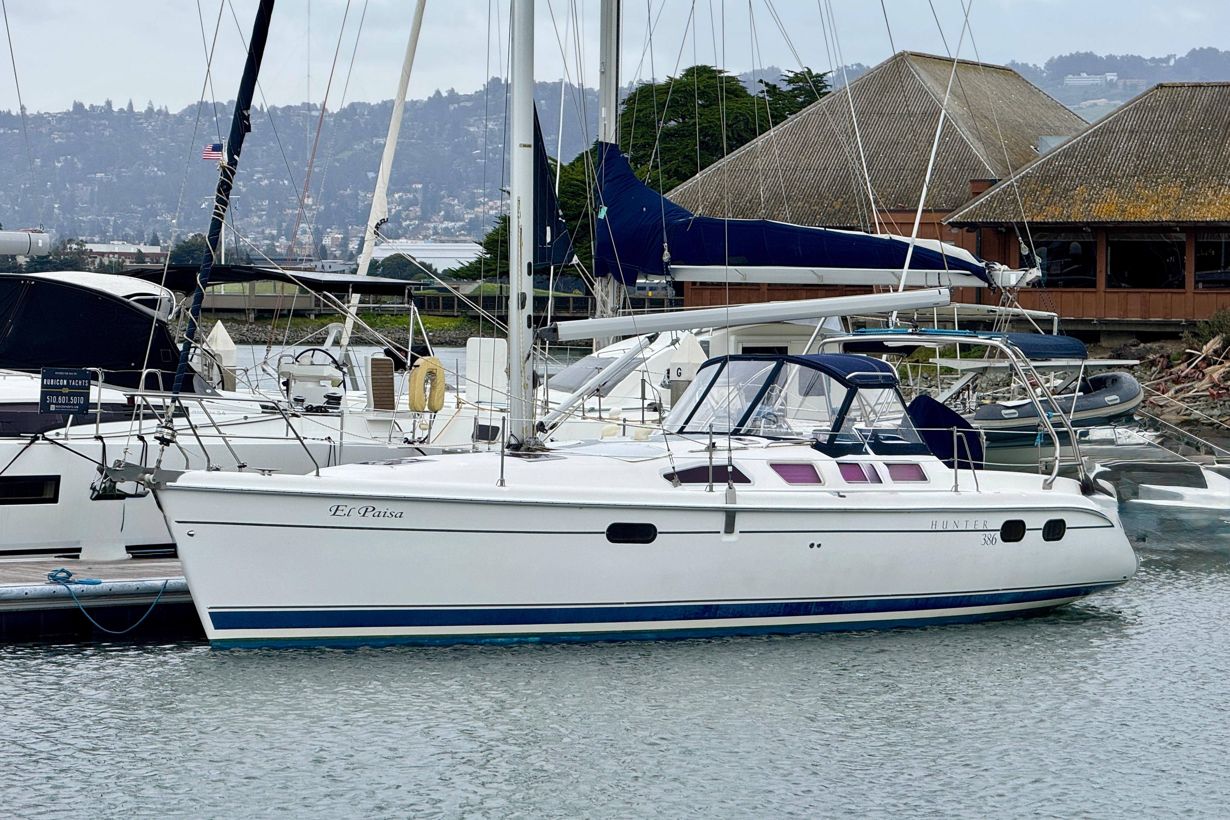 2004 Hunter 386 sailboat docked in marina, featuring sleek design and spacious deck.