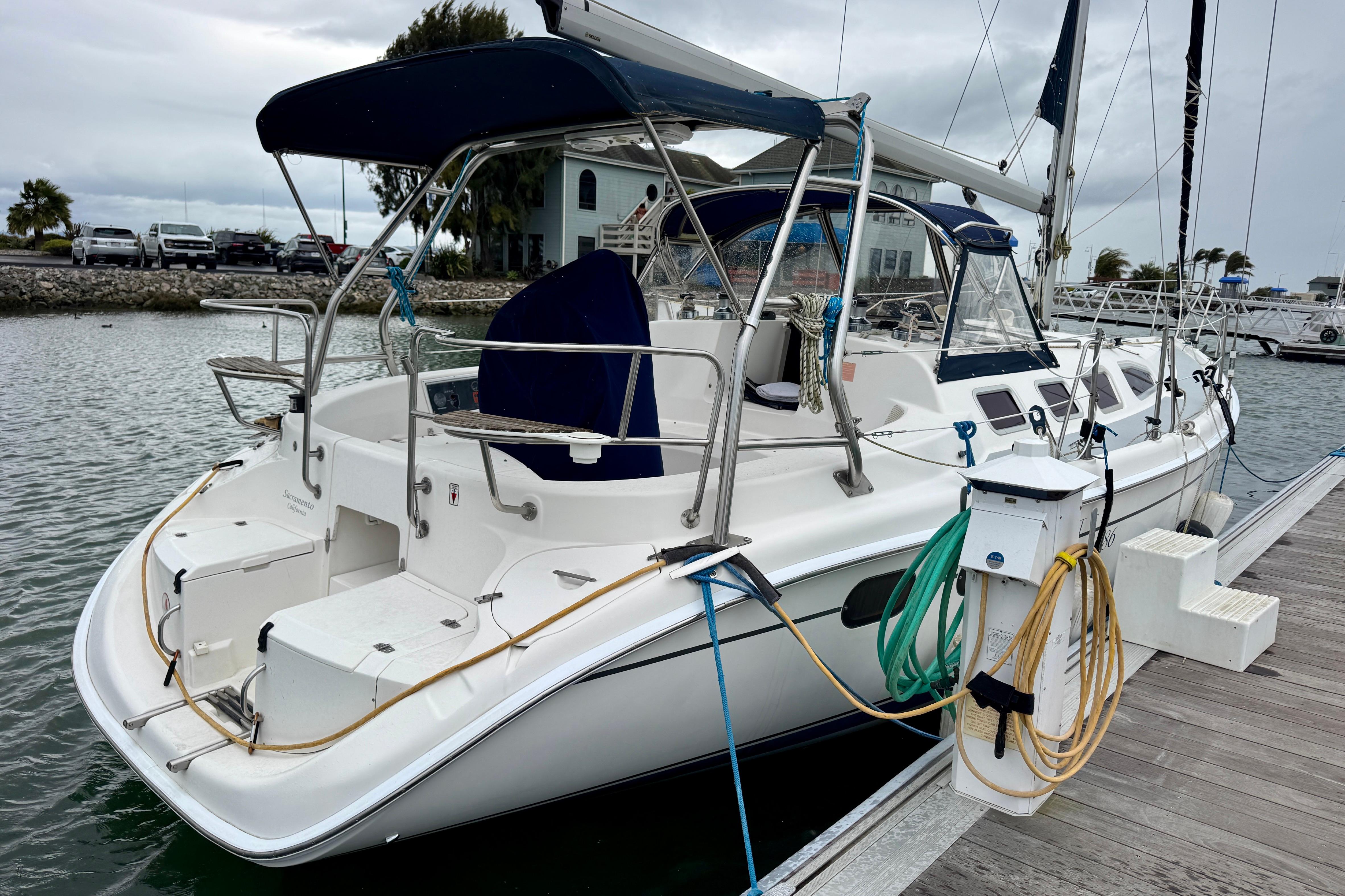 2004 Hunter 386 sailboat docked at marina, featuring spacious cockpit and modern design.