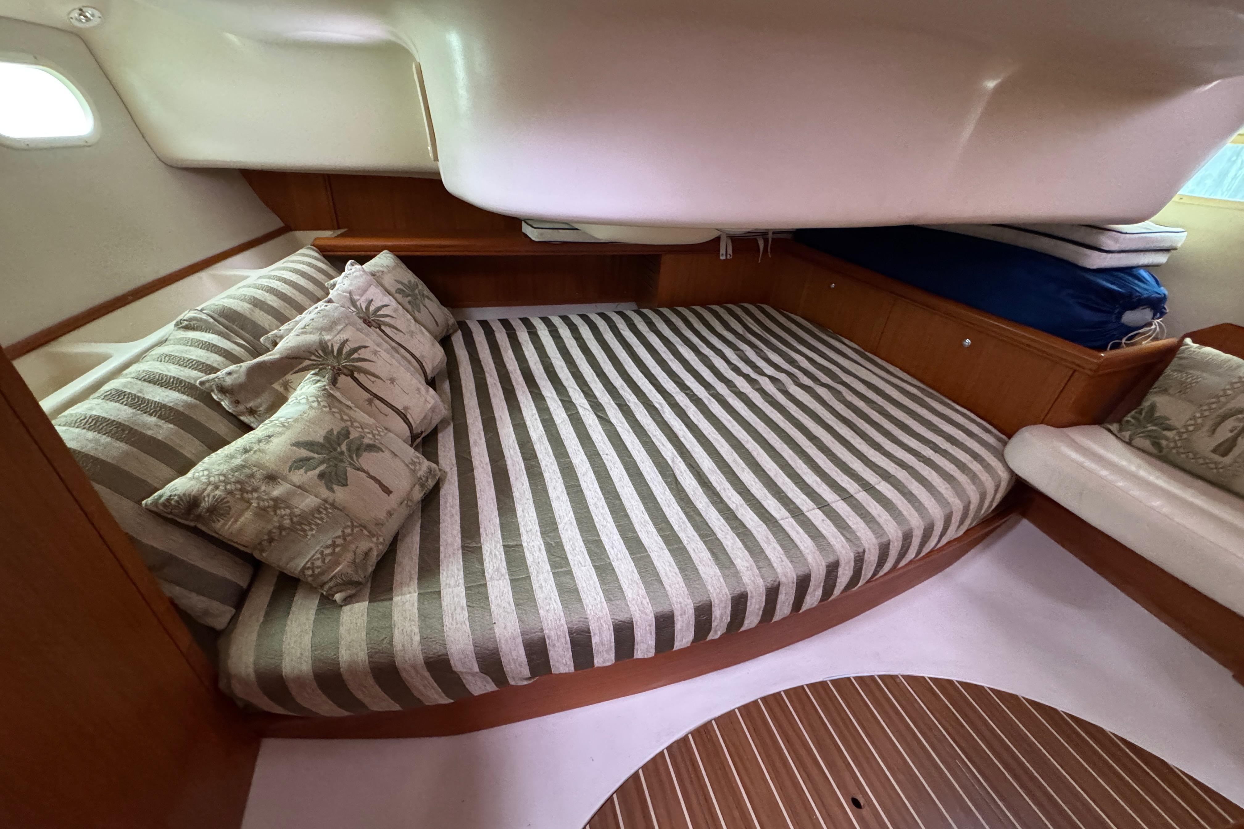 2004 Hunter 386 yacht interior with striped bedding and decorative pillows.