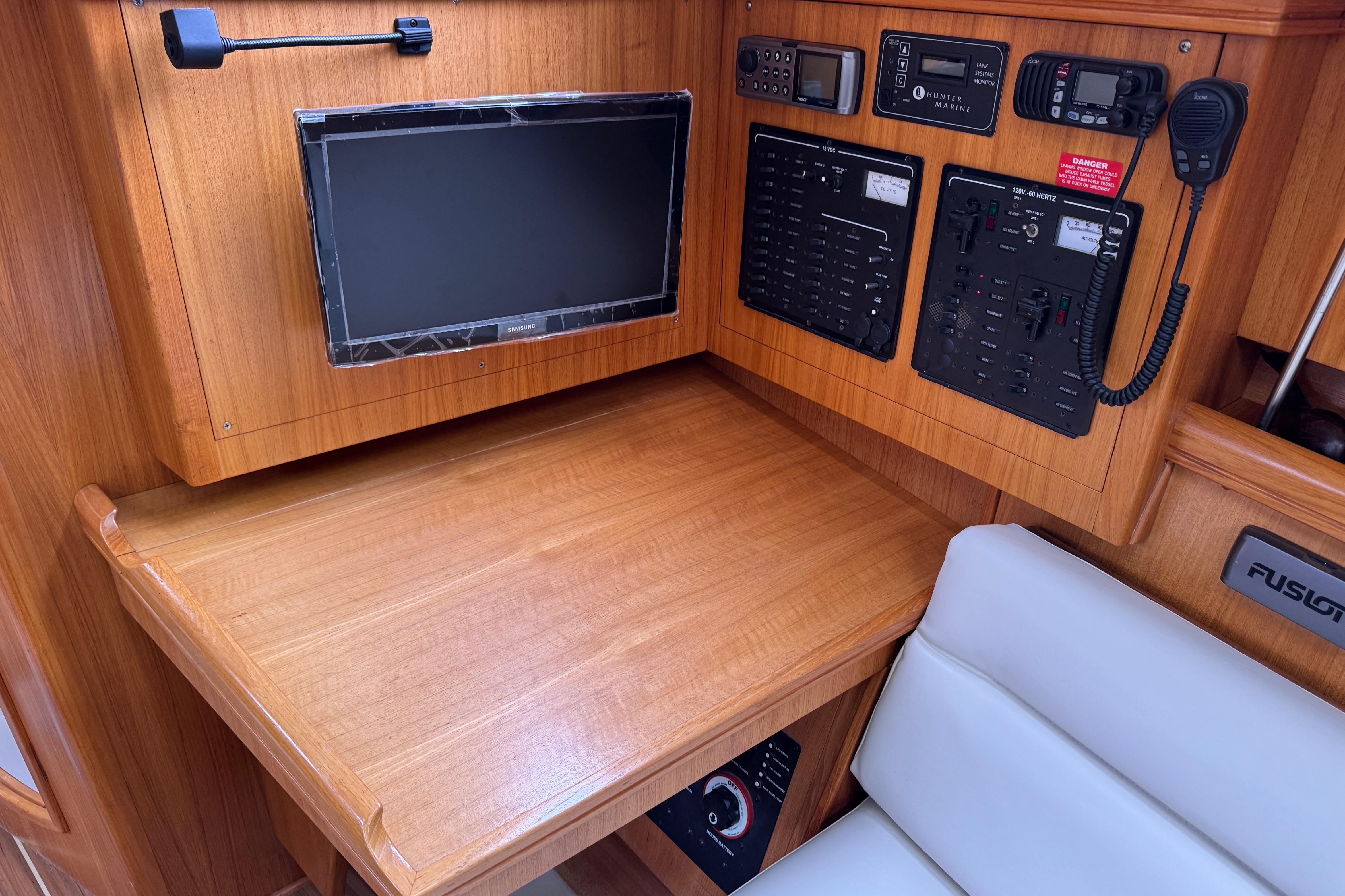 Navigation station of a 2004 Hunter 386 sailboat with control panels and a monitor.
