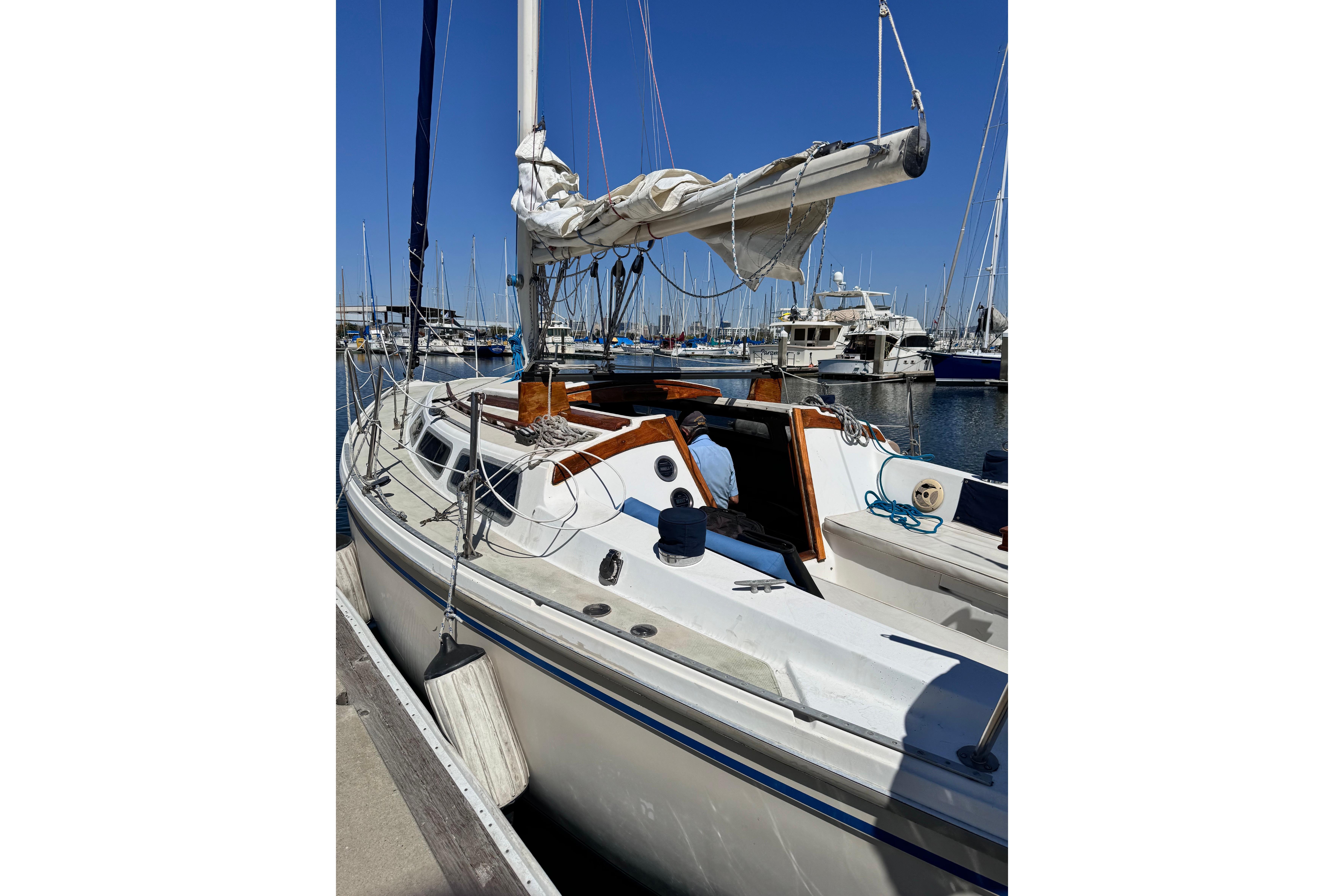 1980 Catalina 30 sailboat docked at marina under clear blue sky.