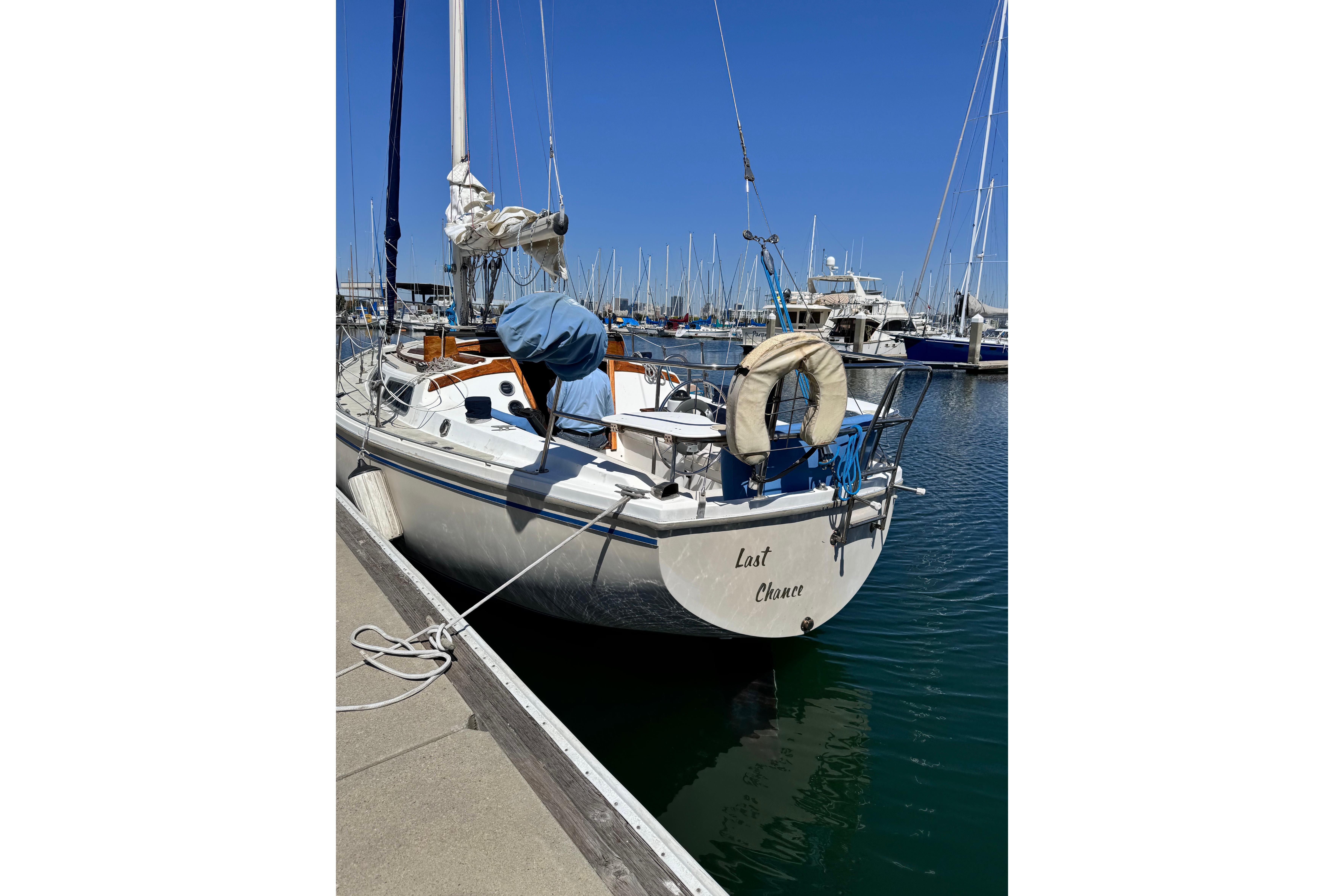 1980 Catalina 30 sailboat docked in marina under clear blue sky.