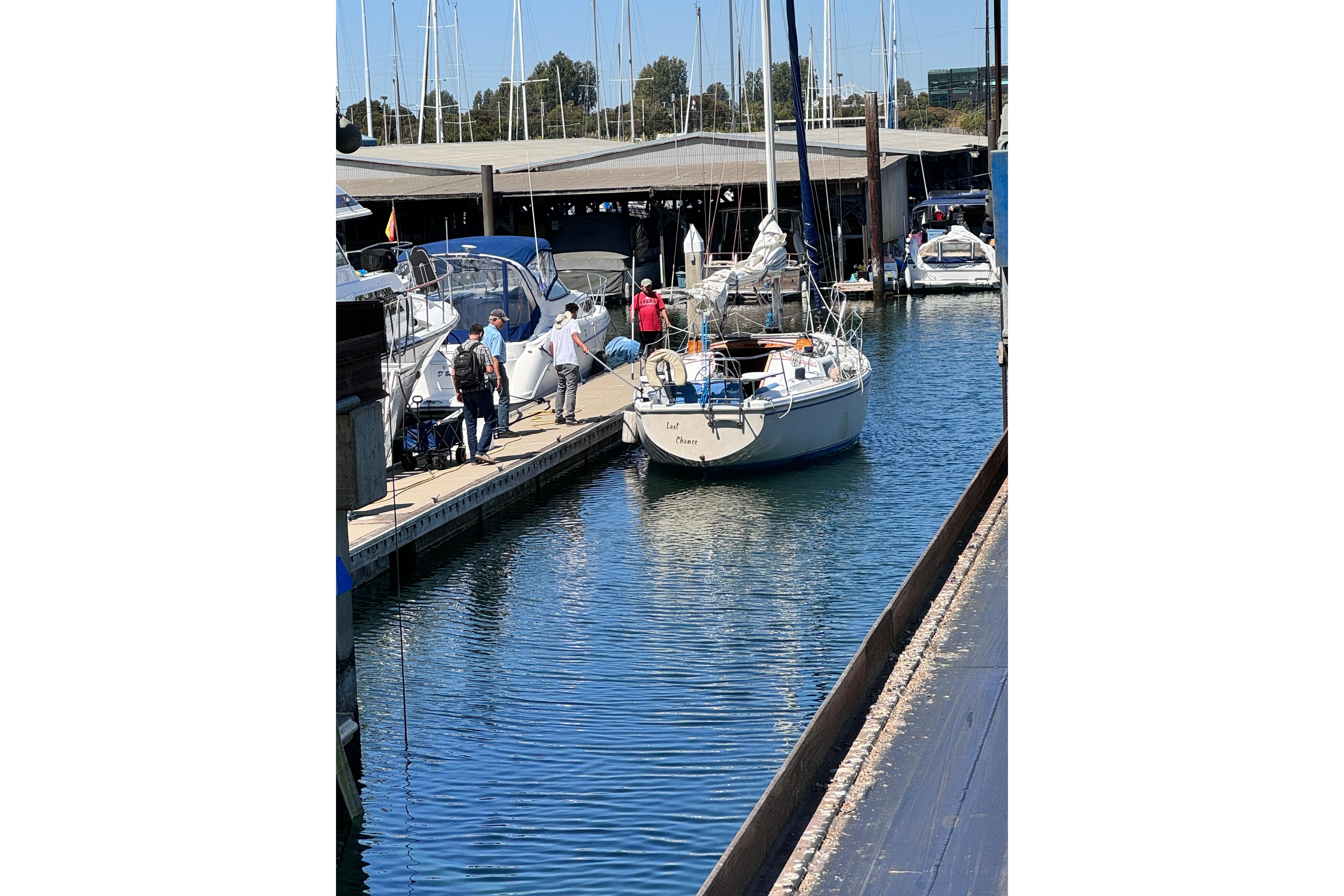 1980 Catalina 30 sailboat docked at marina with people nearby.