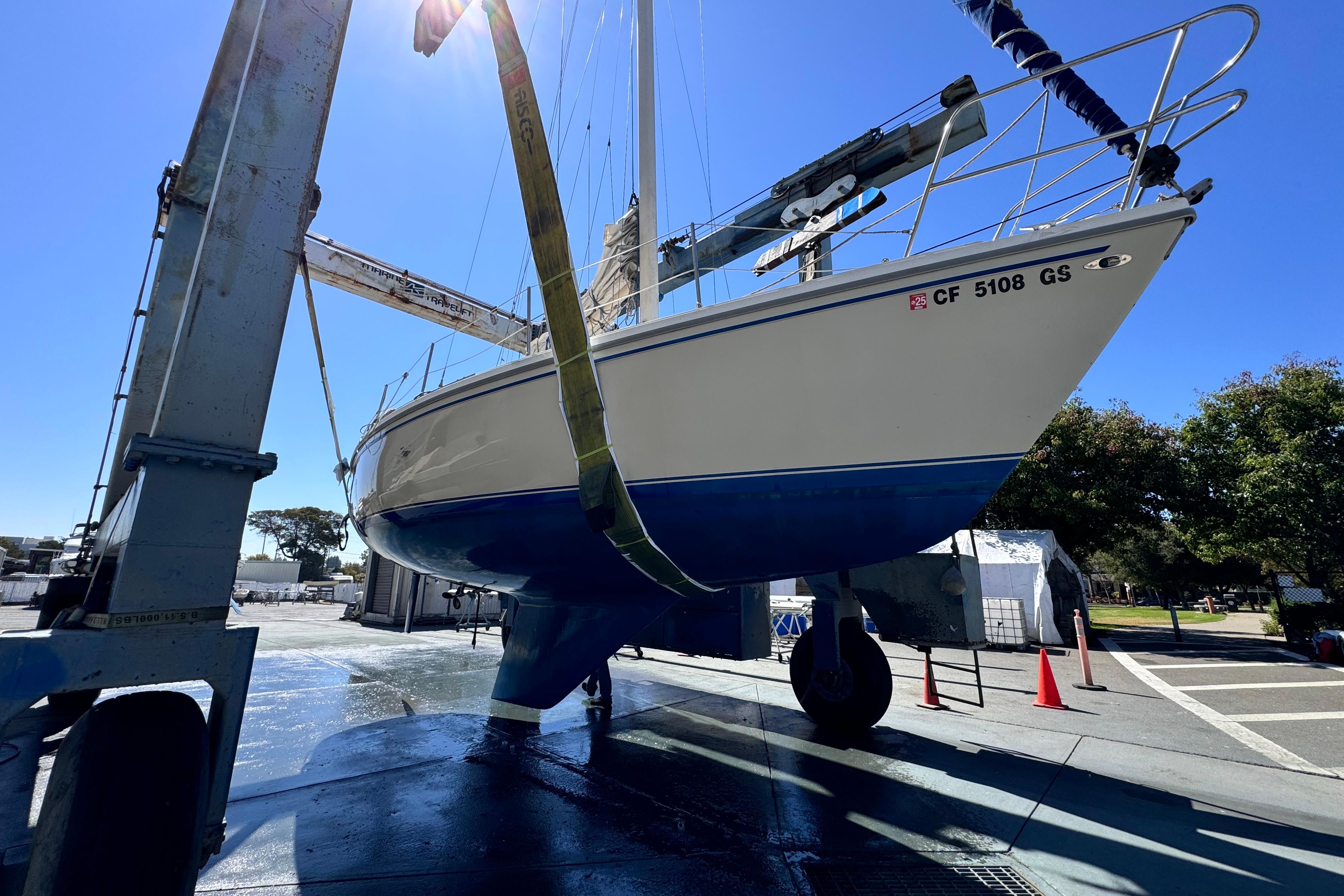 1980 Catalina 30 sailboat in dry dock, undergoing maintenance under clear blue sky.