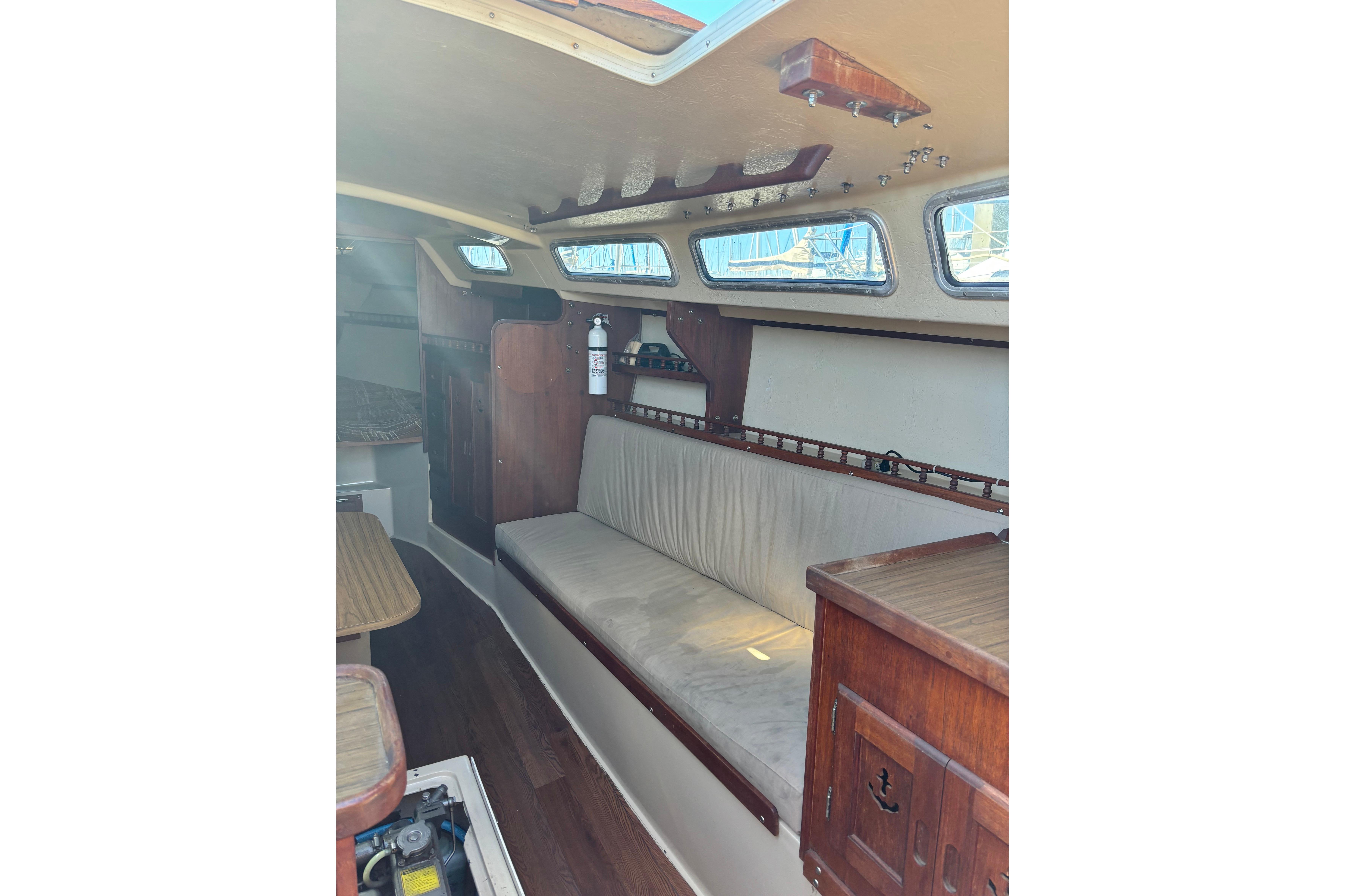 Interior of 1980 Catalina 30 sailboat with wooden furnishings and cushioned seating.