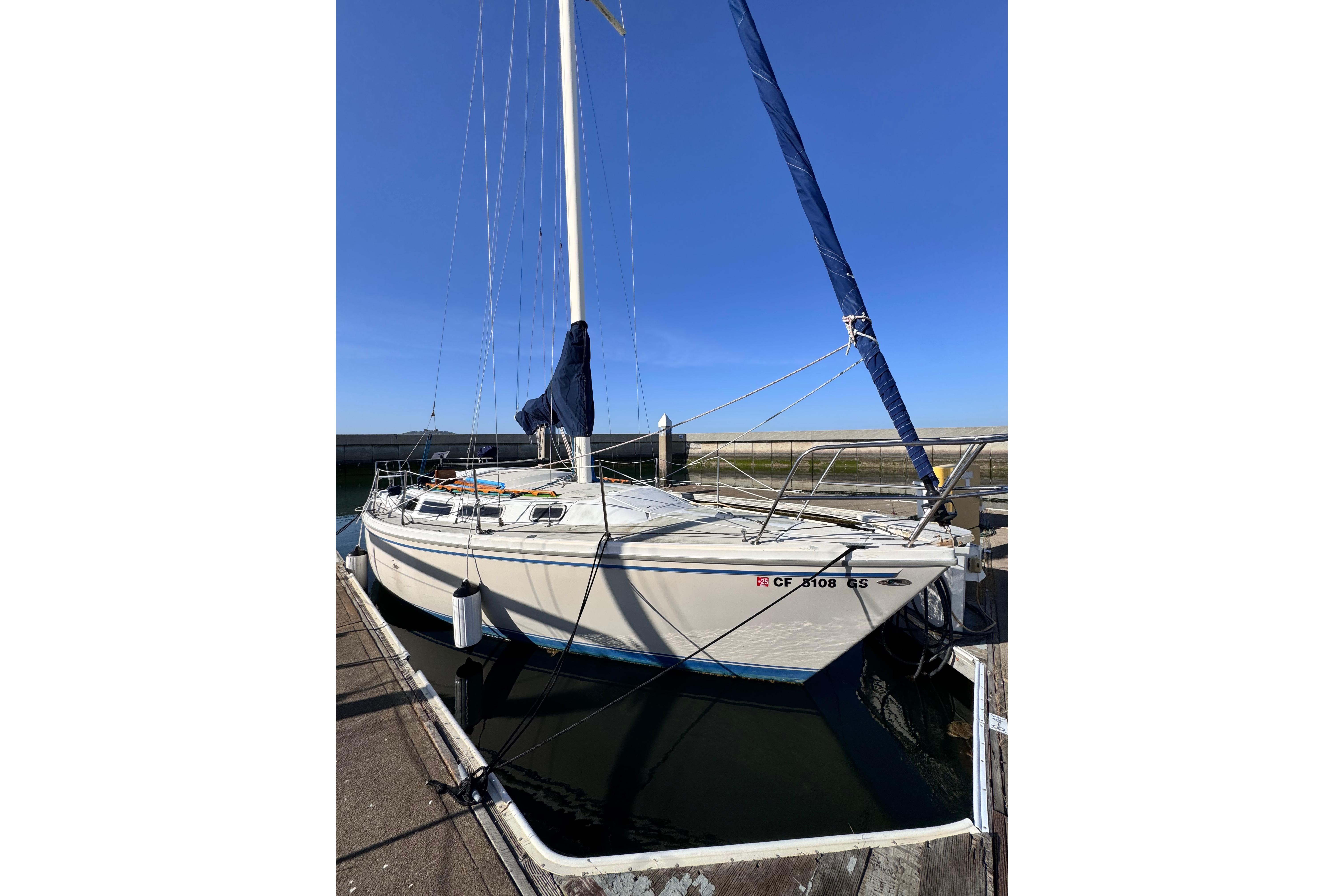 1980 Catalina 30 sailboat docked under clear blue sky.