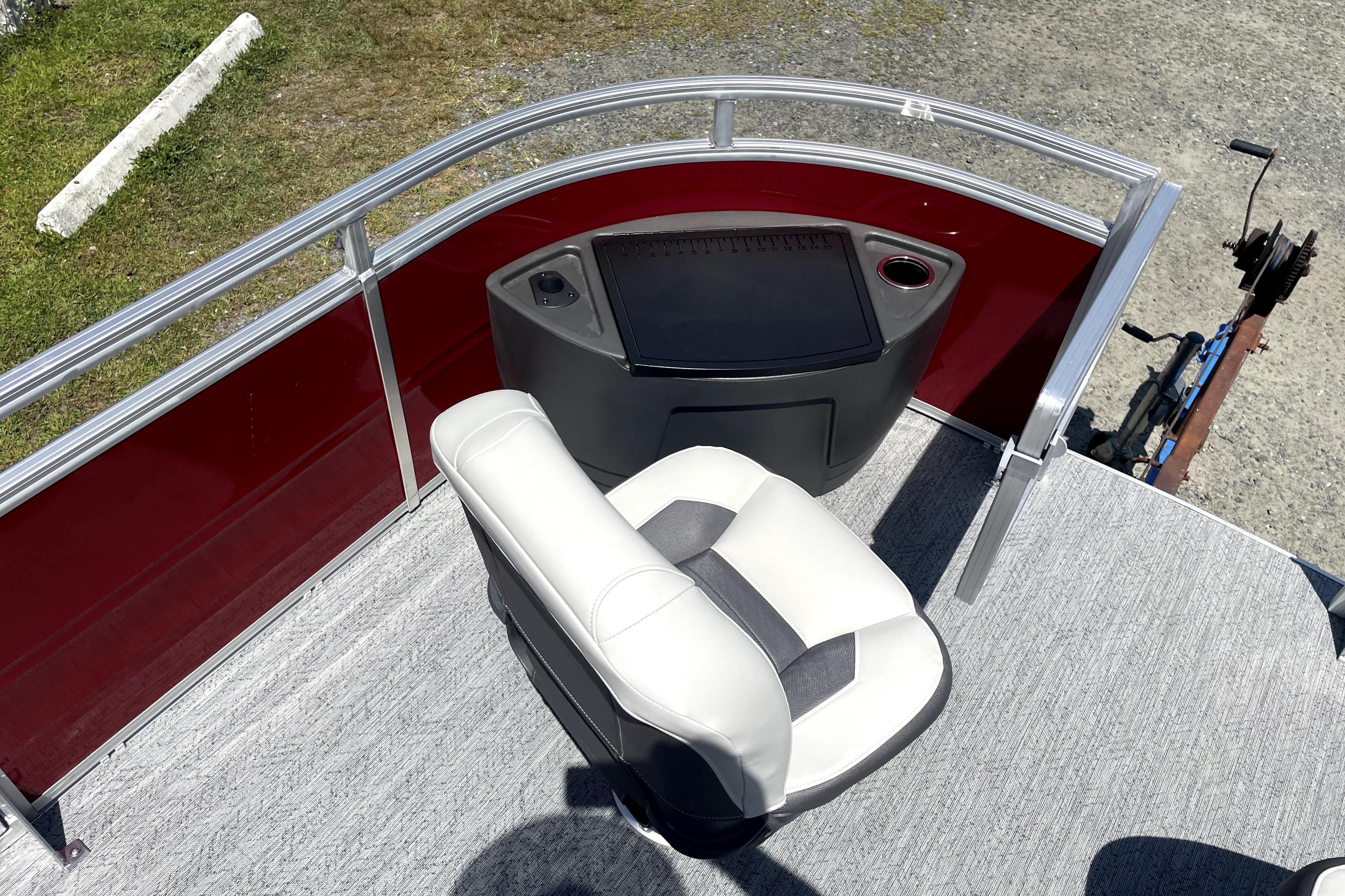 2026 Sun Tracker Fishin' Barge 22 DLX boat interior with captain's chair and control panel.