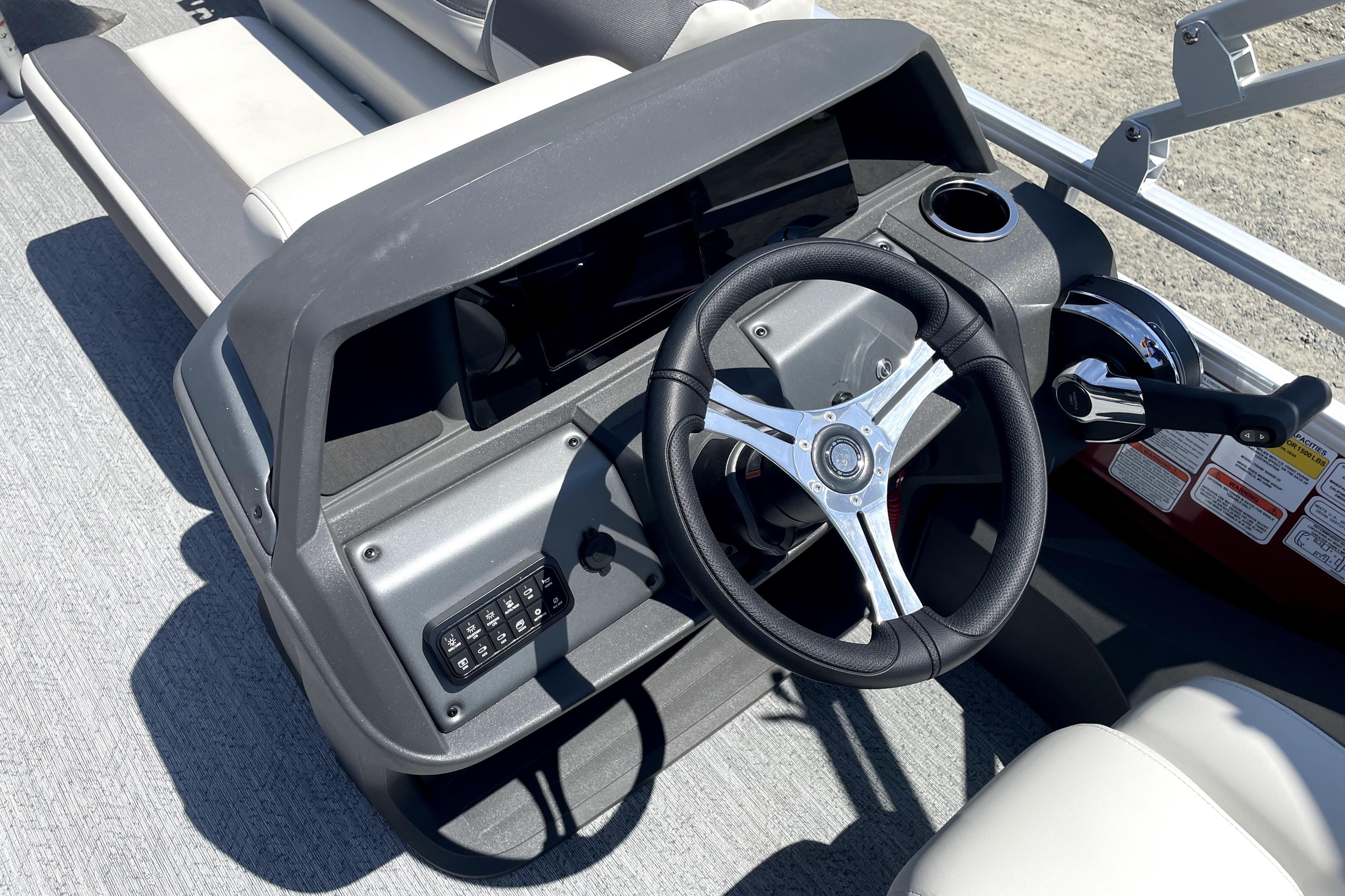 2026 Sun Tracker Fishin' Barge 22 DLX steering console with modern controls and seating.