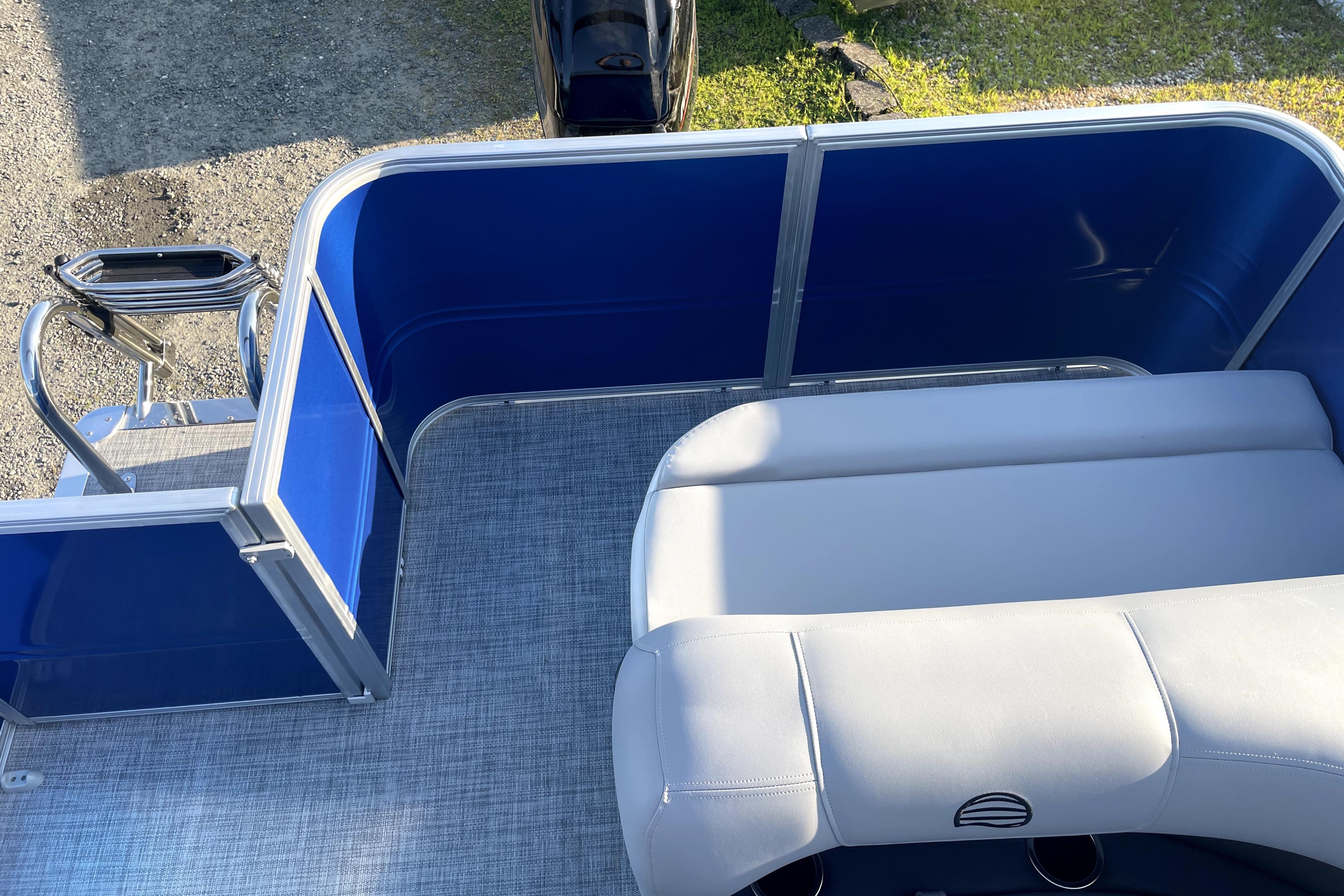 2026 Sun Tracker Fishin' Barge 22 DLX interior with blue panels and gray seating.