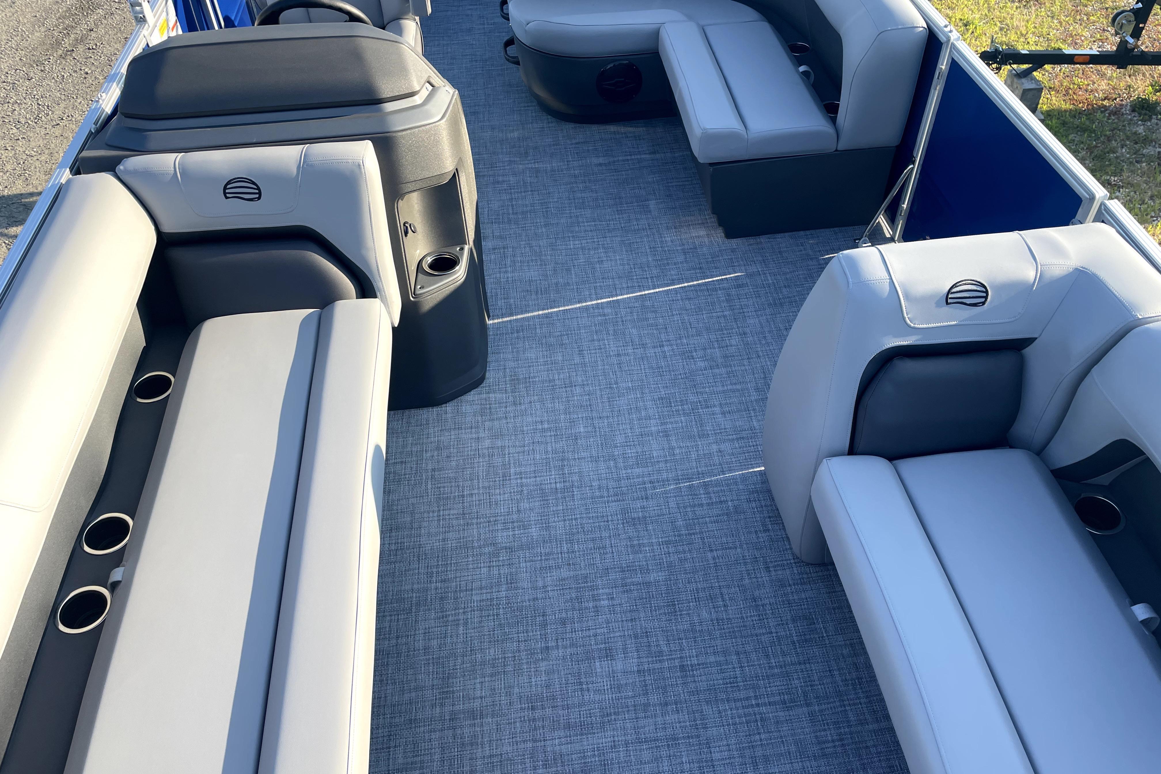 2026 Sun Tracker Fishin' Barge 22 DLX interior with gray seating and cup holders.