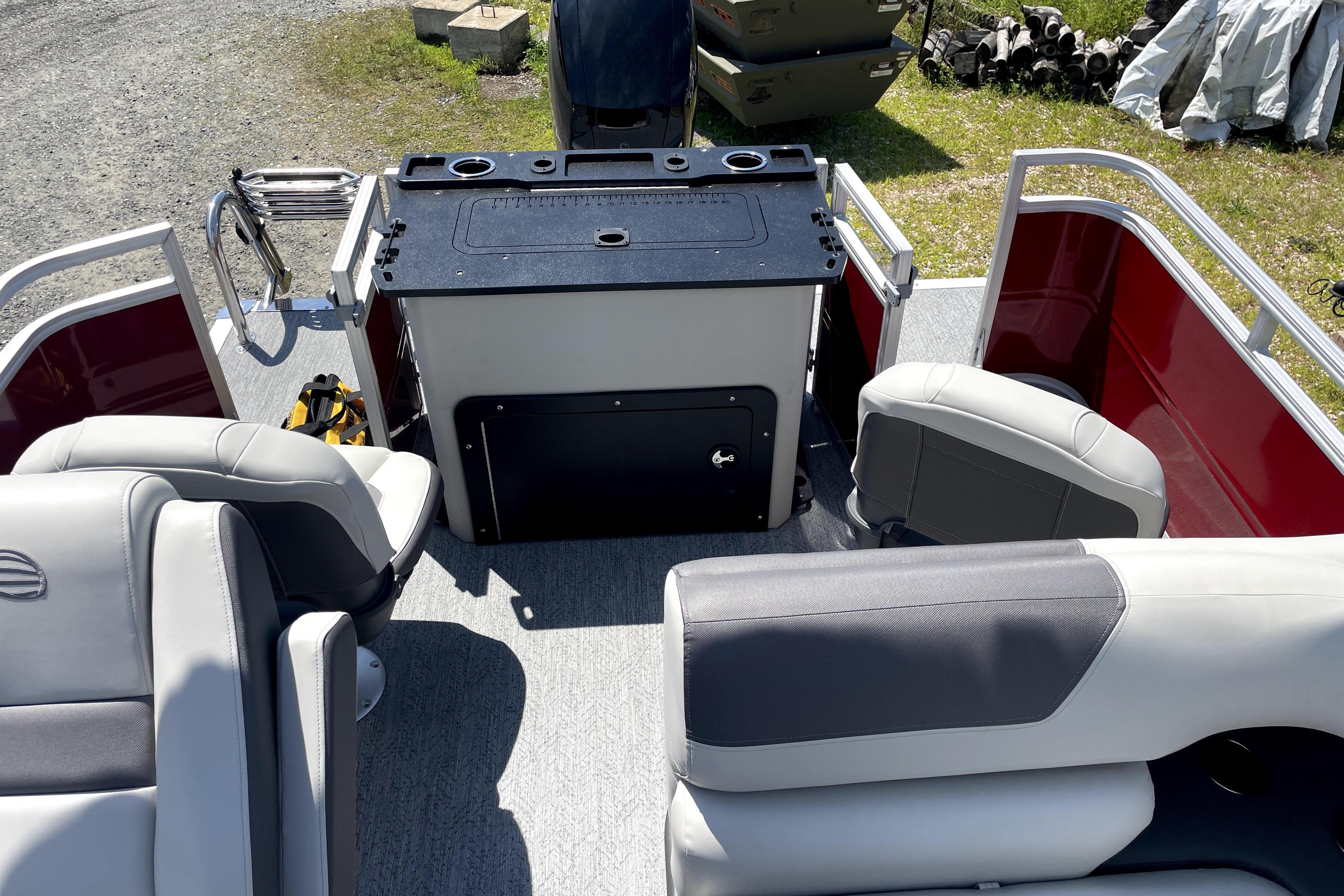 2026 Sun Tracker Fishin' Barge 22 DLX interior with seating and fishing station.