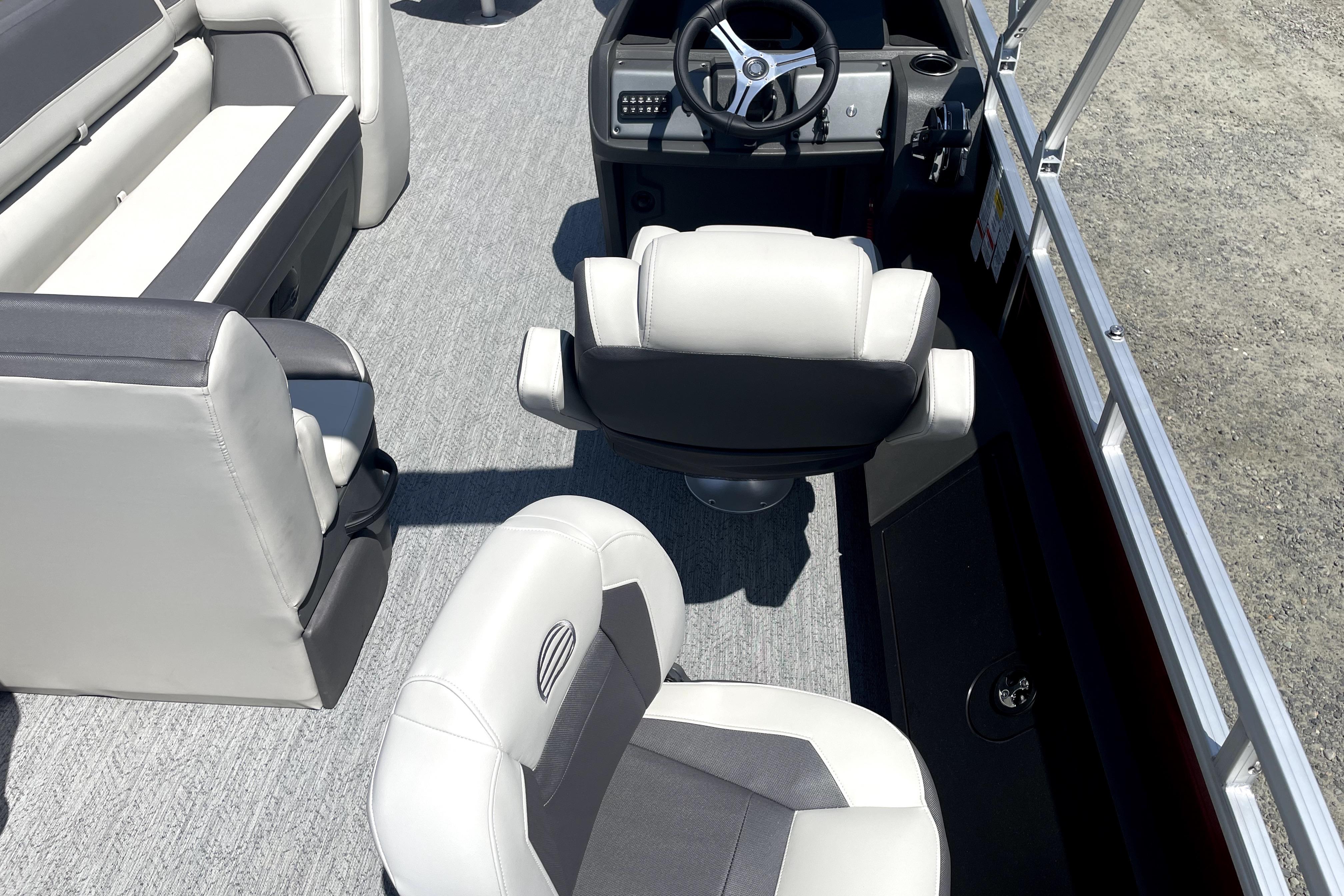 2026 Sun Tracker Fishin' Barge 22 DLX interior with steering wheel and seating.