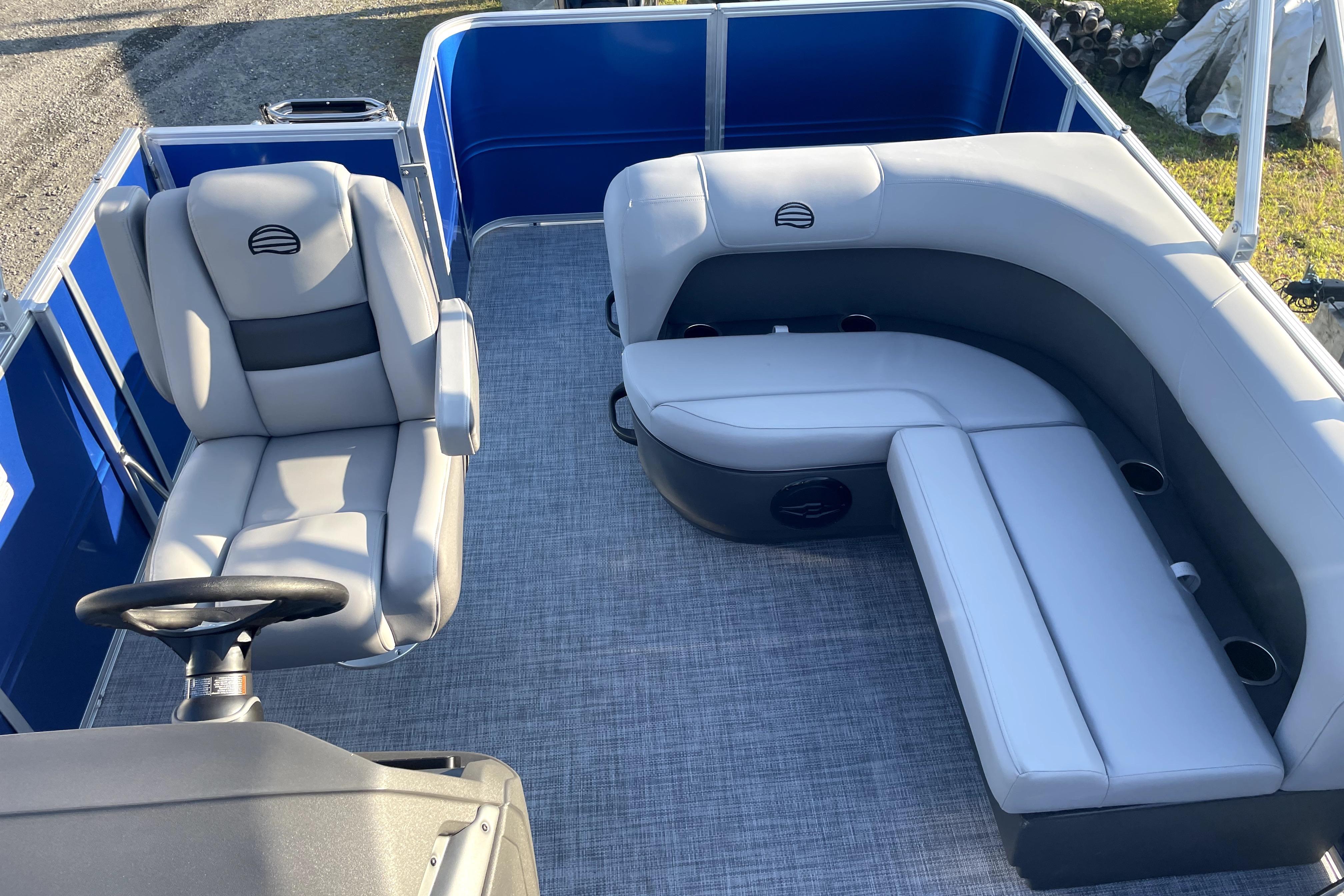 2026 Sun Tracker Fishin' Barge 22 DLX interior with gray seating and steering wheel.