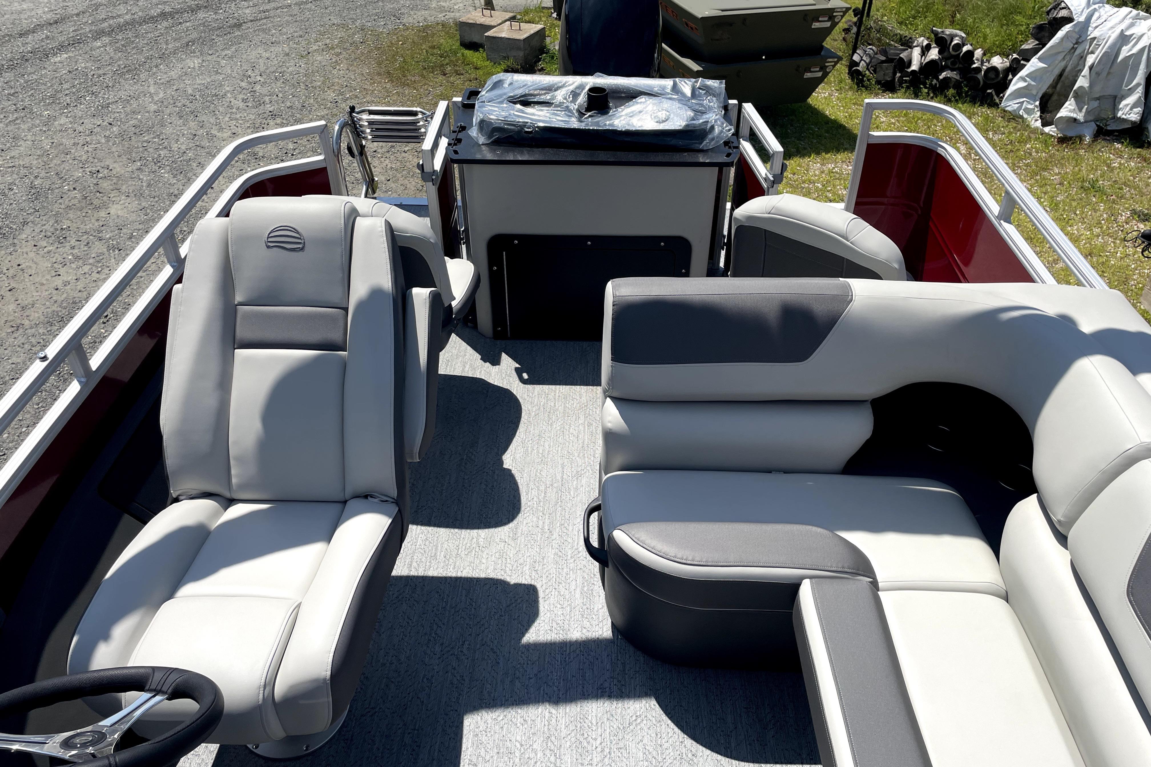 2026 Sun Tracker Fishin' Barge 22 DLX interior with plush seating and steering console.