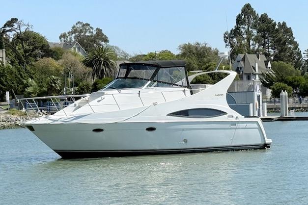 1997 Carver 350 Mariner yacht on calm water near a marina.