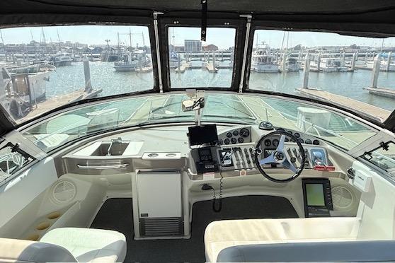1997 Carver 350 Mariner helm with marina view, featuring navigation equipment and steering wheel.