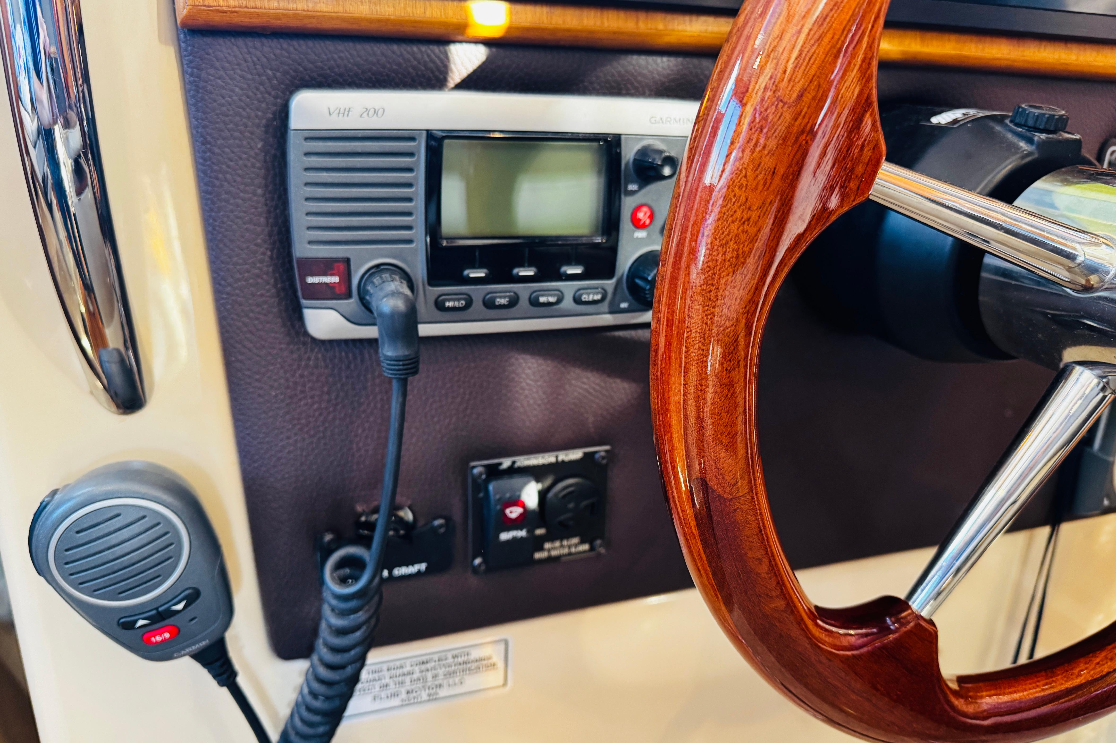 2012 Ranger Tugs R-31 helm with wooden steering wheel and VHF radio.