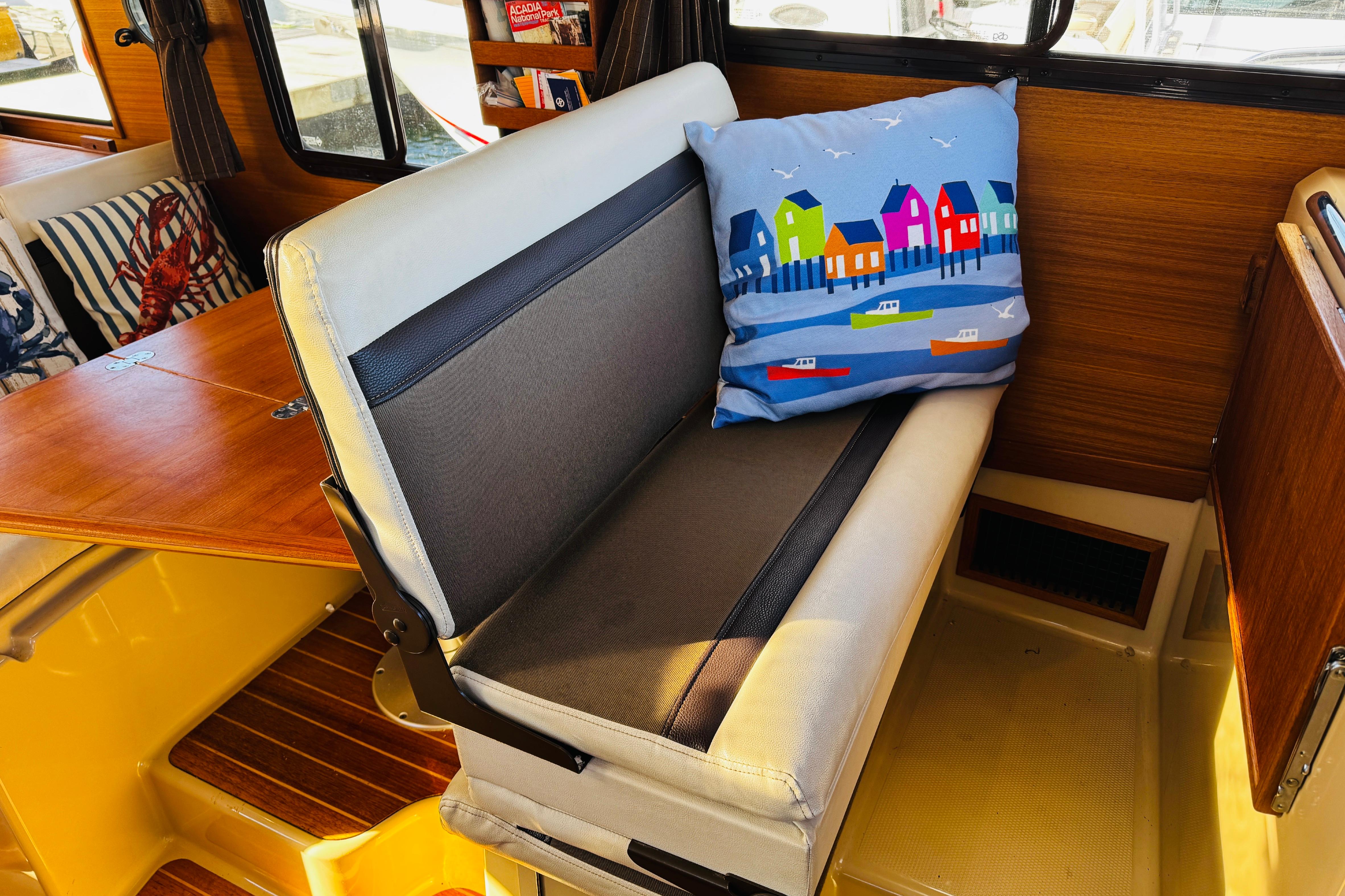 Interior of 2012 Ranger Tugs R-31 with colorful cushion and wooden accents.