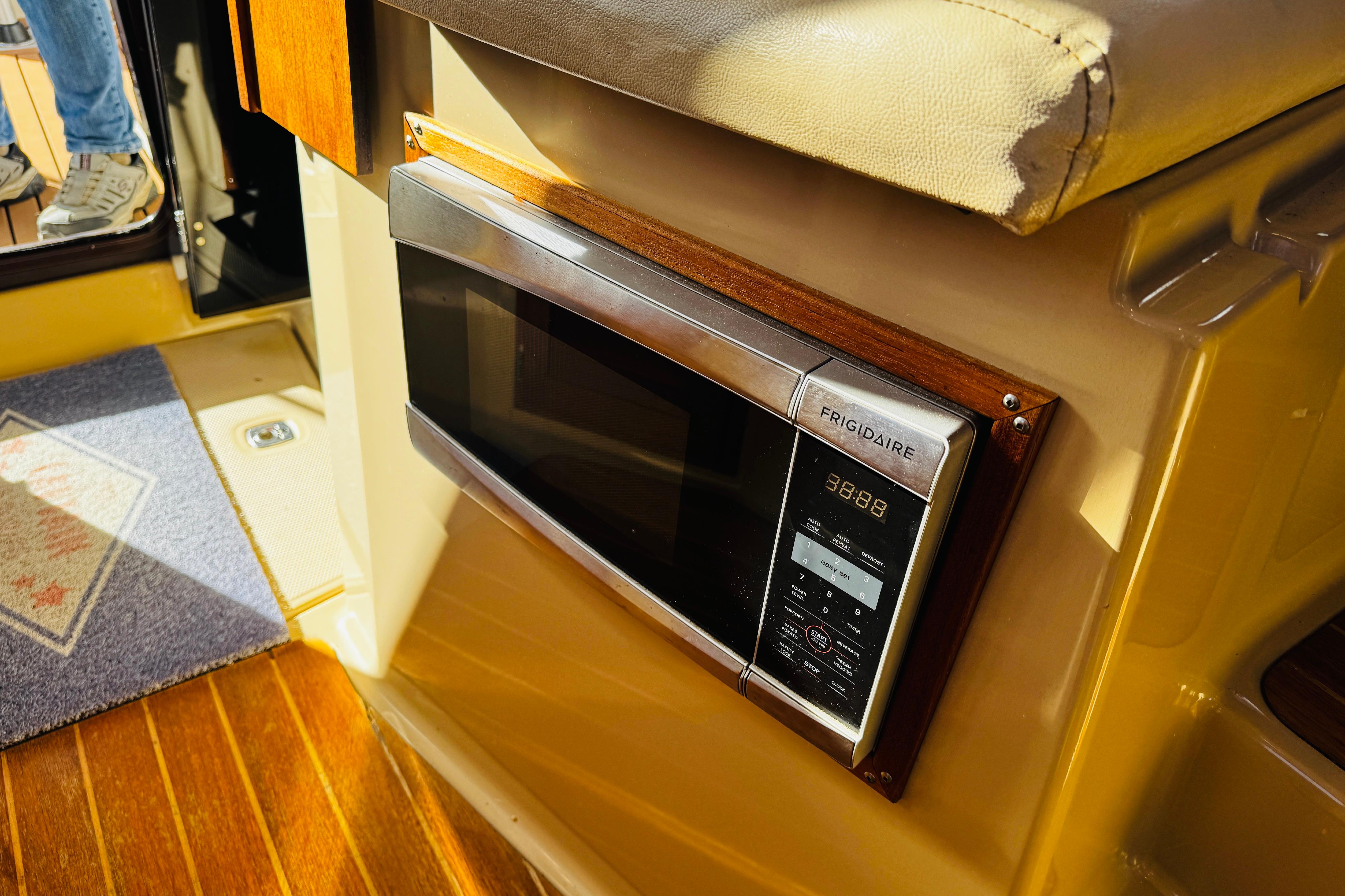 Frigidaire microwave in 2012 Ranger Tugs R-31 boat interior, with wooden flooring.