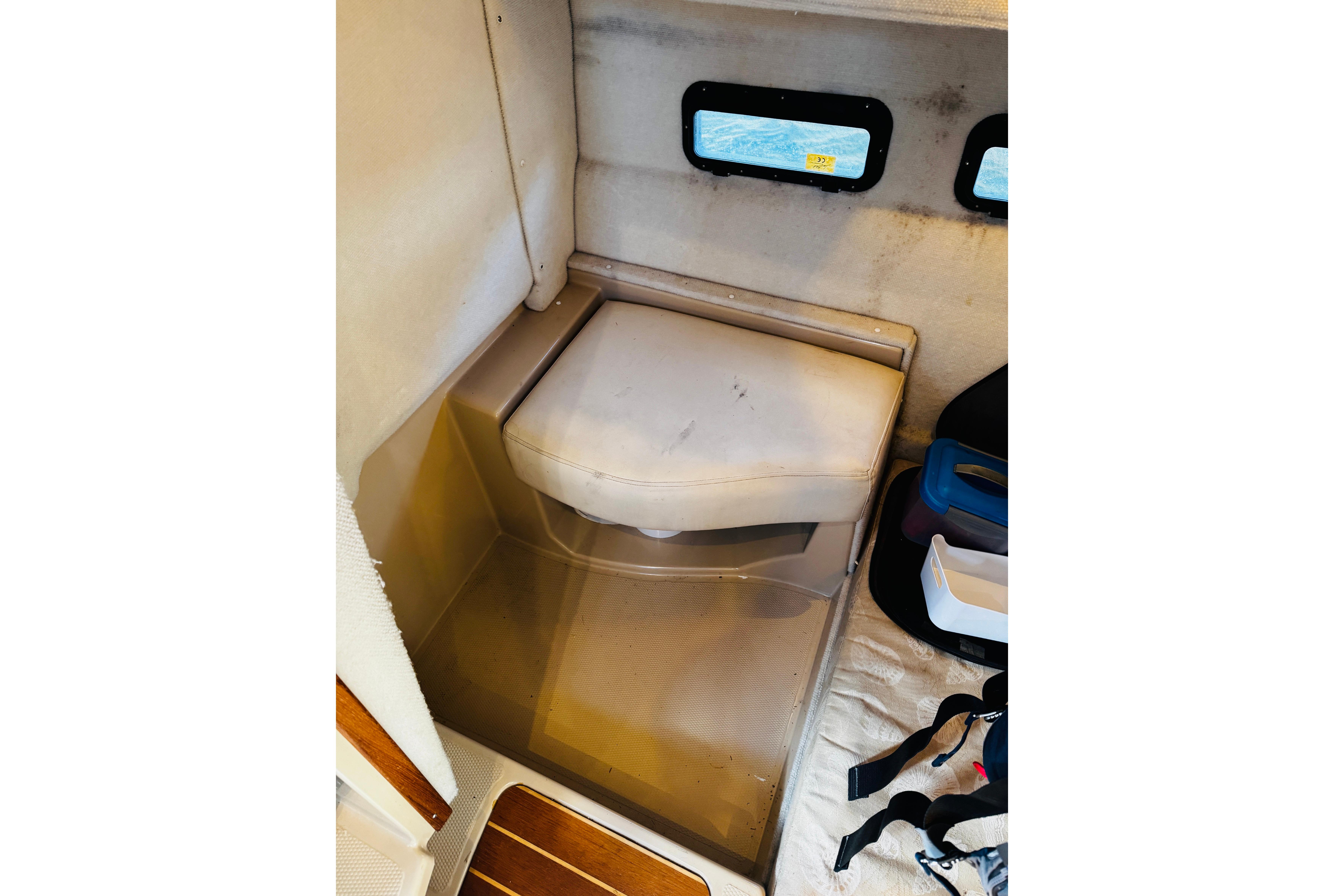 2012 Ranger Tugs R-31 interior with cushioned seat and small windows.