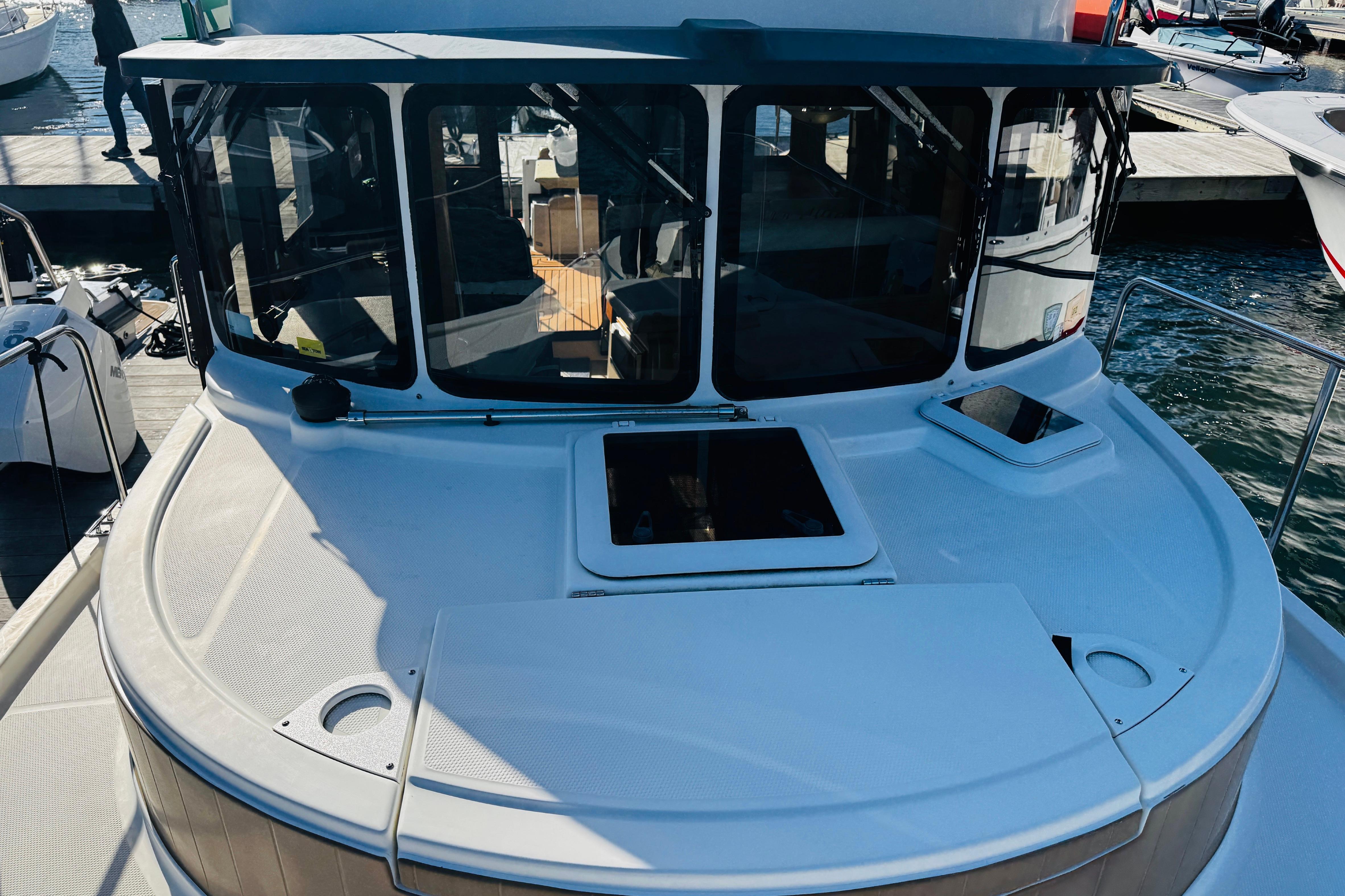 2012 Ranger Tugs R-31 boat docked, showcasing front deck and cabin windows.