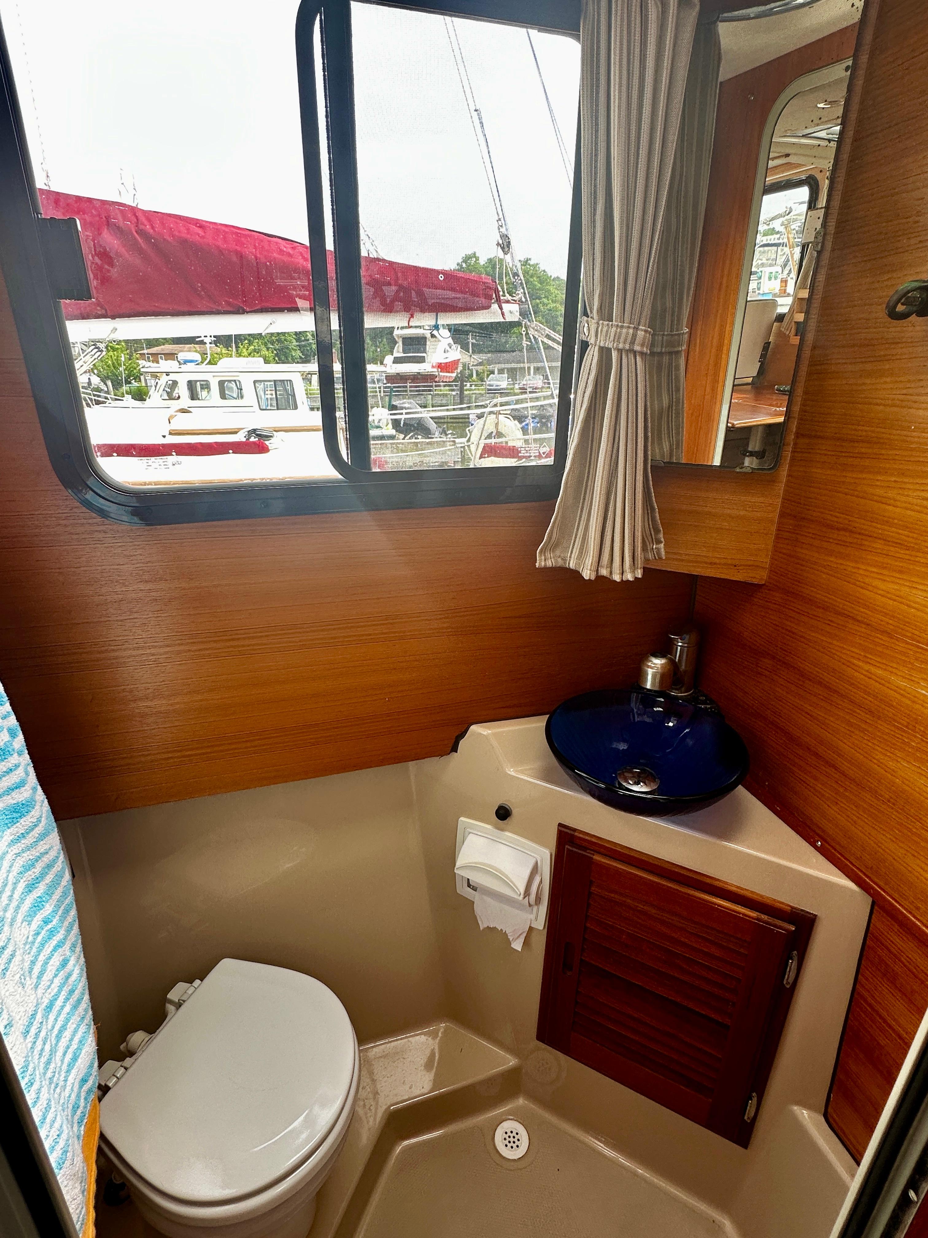2014 American Tug R-27 bathroom with toilet, sink, and window view.