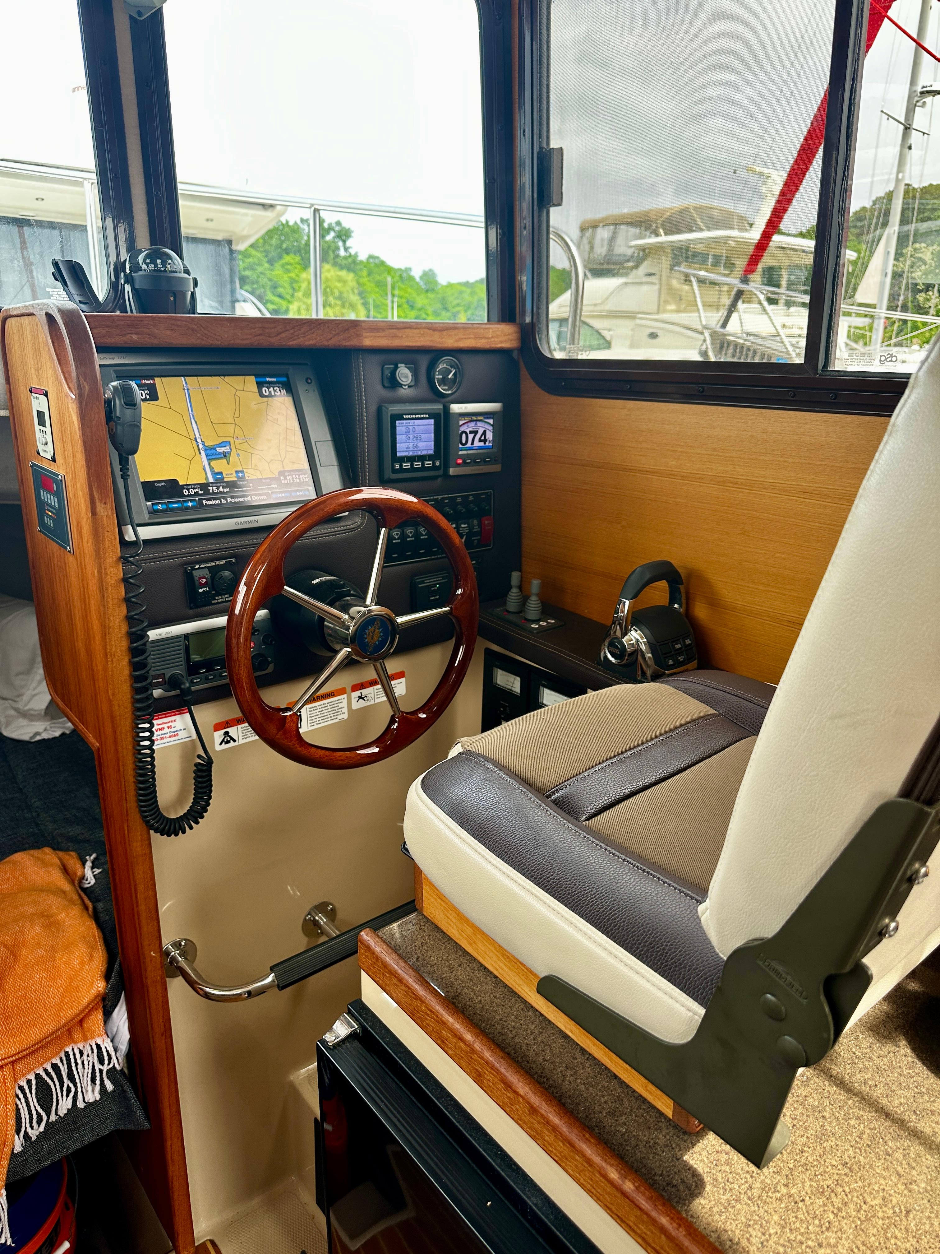 Interior of 2014 American Tug R-27 boat with navigation controls and captainu0027s chair.