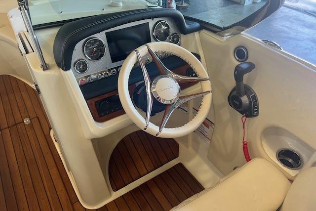 2024 Chris-Craft Launch 27 cockpit with wooden flooring and modern steering controls.