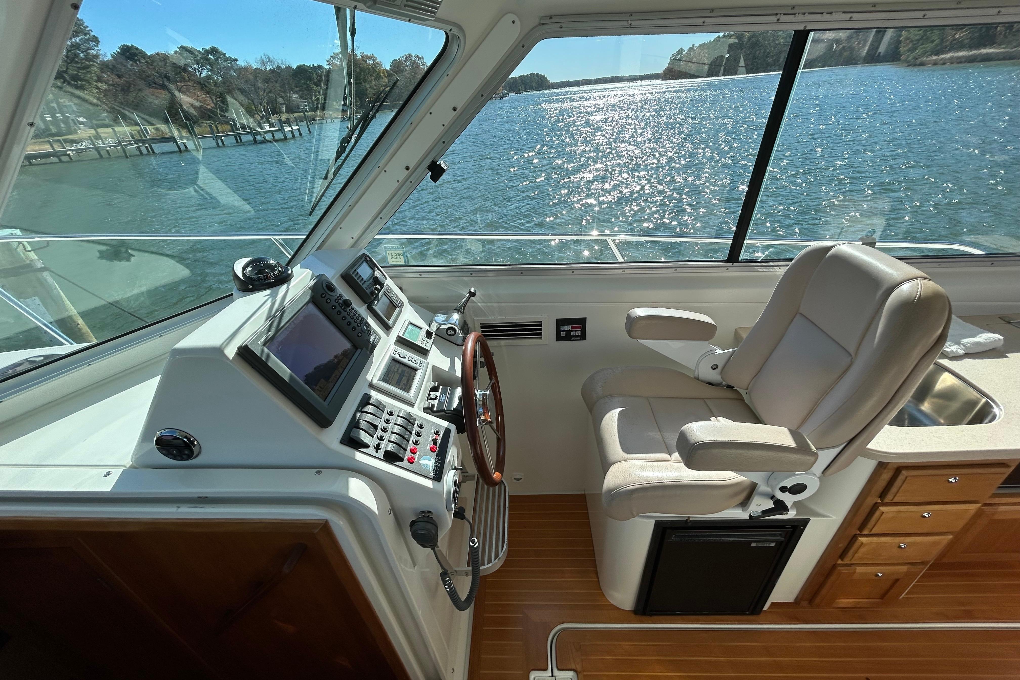 Helm of 2008 Back Cove 33 boat with leather seat and navigation controls.