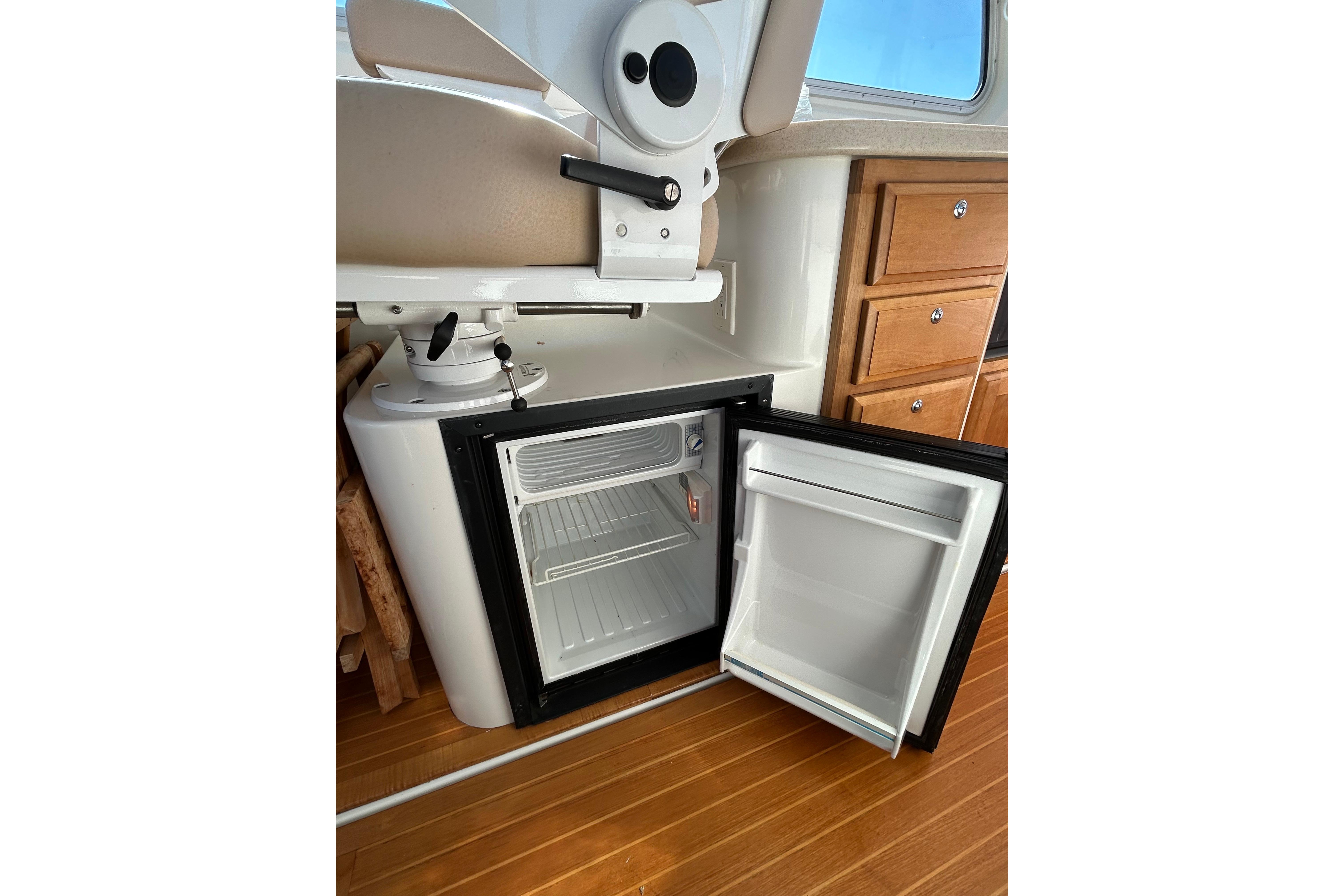 2008 Back Cove 33 interior with open mini fridge and wooden cabinetry.