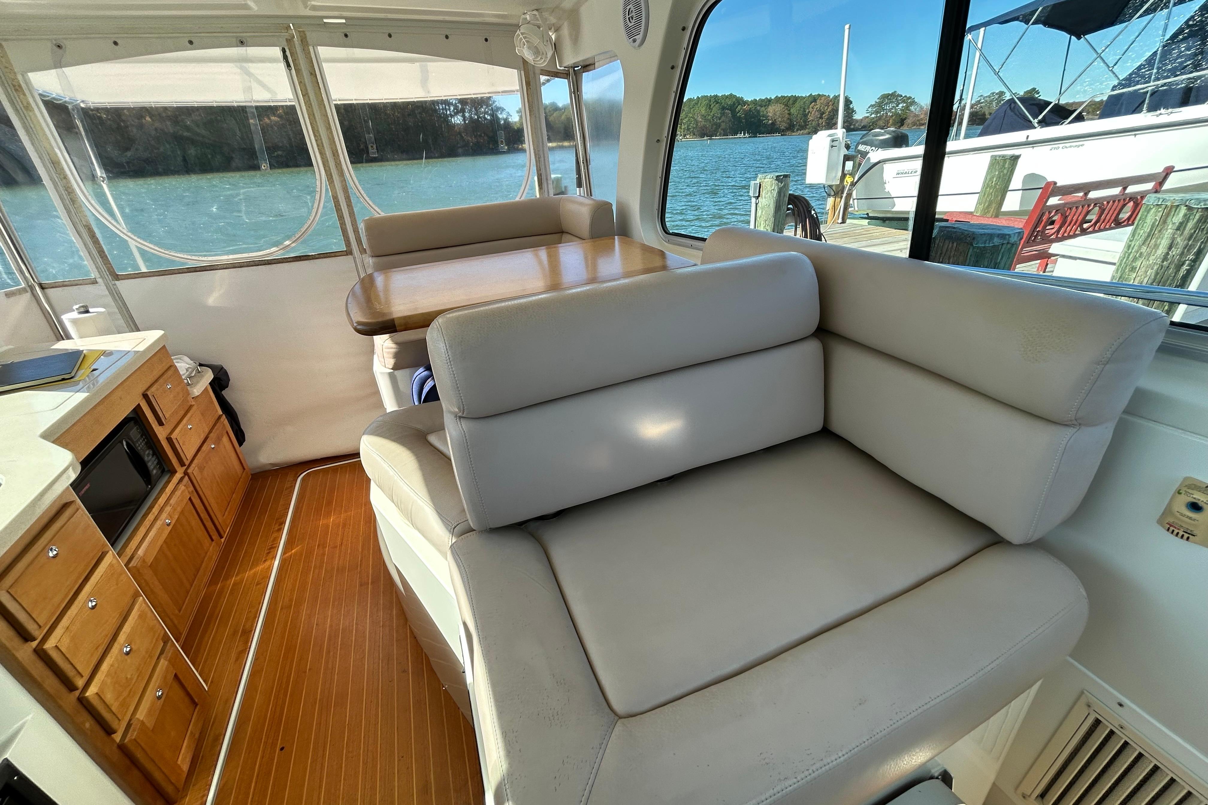 Interior of 2008 Back Cove 33 yacht with seating, table, and cabinetry.