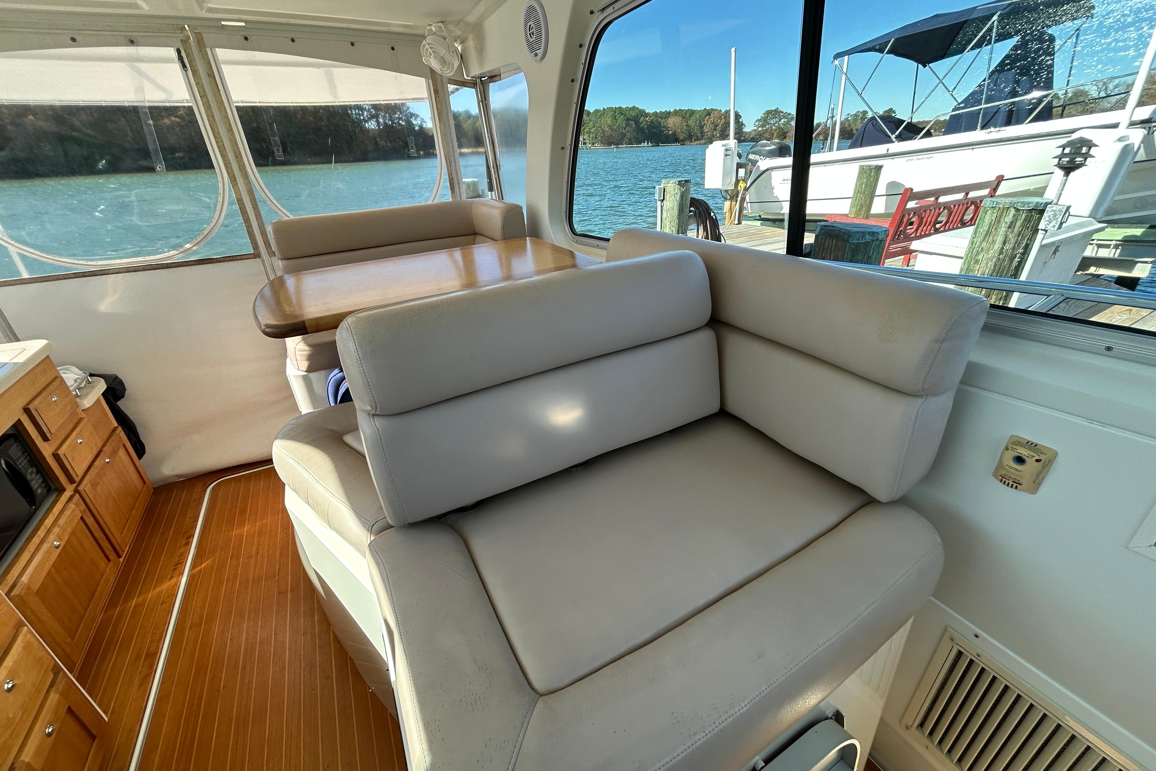 Interior of 2008 Back Cove 33 boat with seating and dining area by the water.