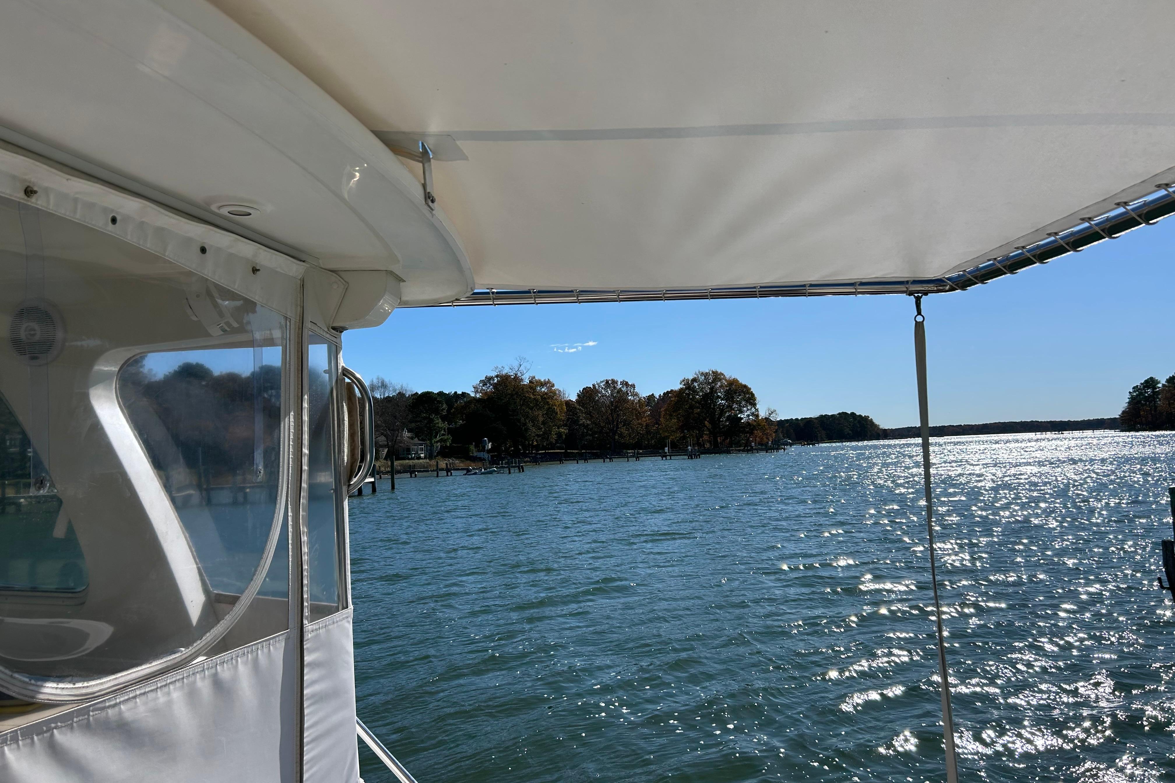 2008 Back Cove 33 boat view, sunny day on sparkling water, scenic shoreline.