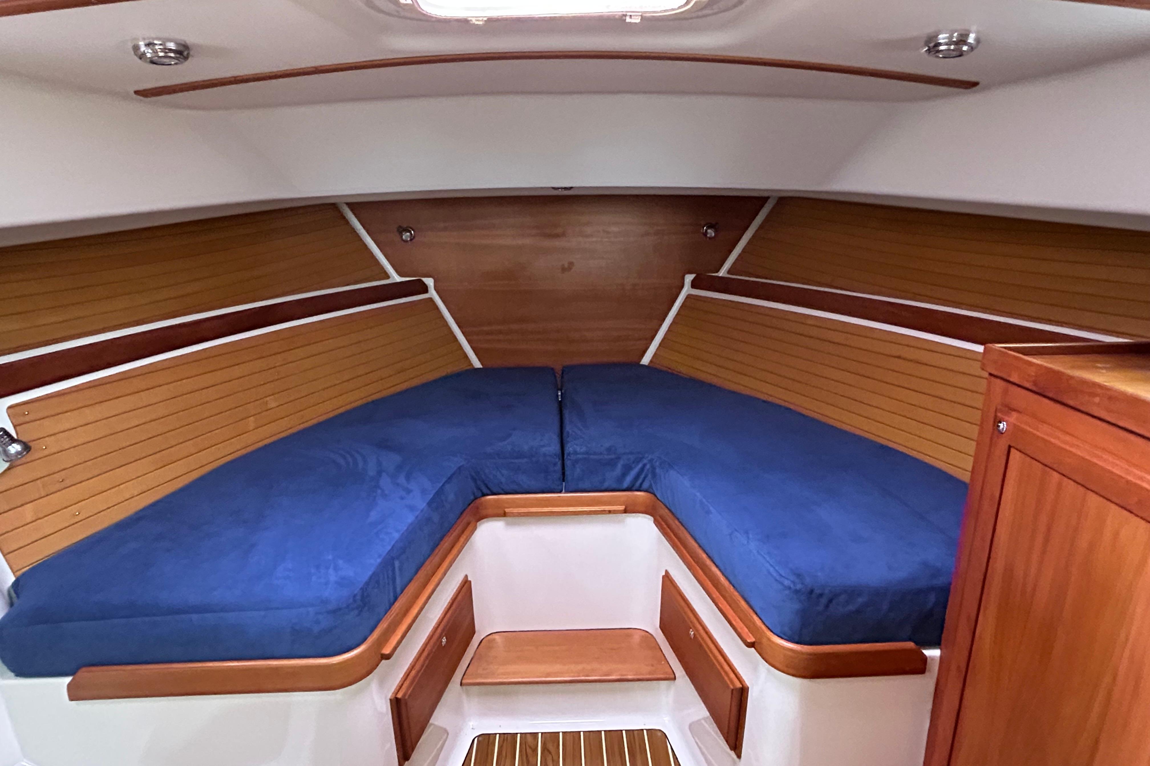2008 Back Cove 33 interior cabin with blue cushions and wooden paneling.