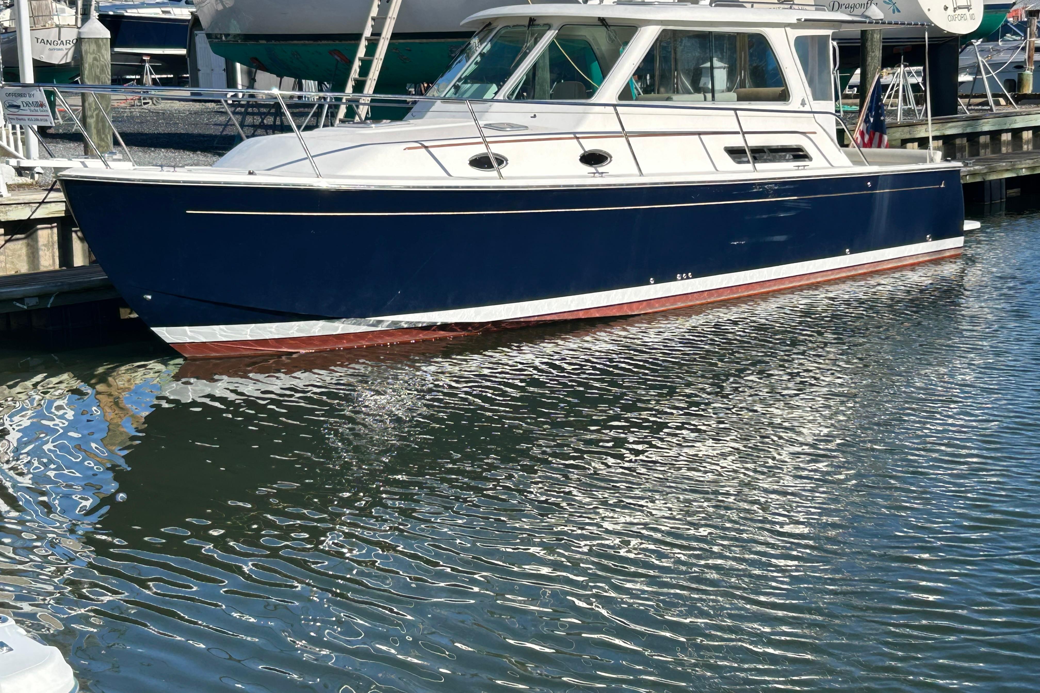 2008 Back Cove 33 boat docked in marina, reflecting on water.