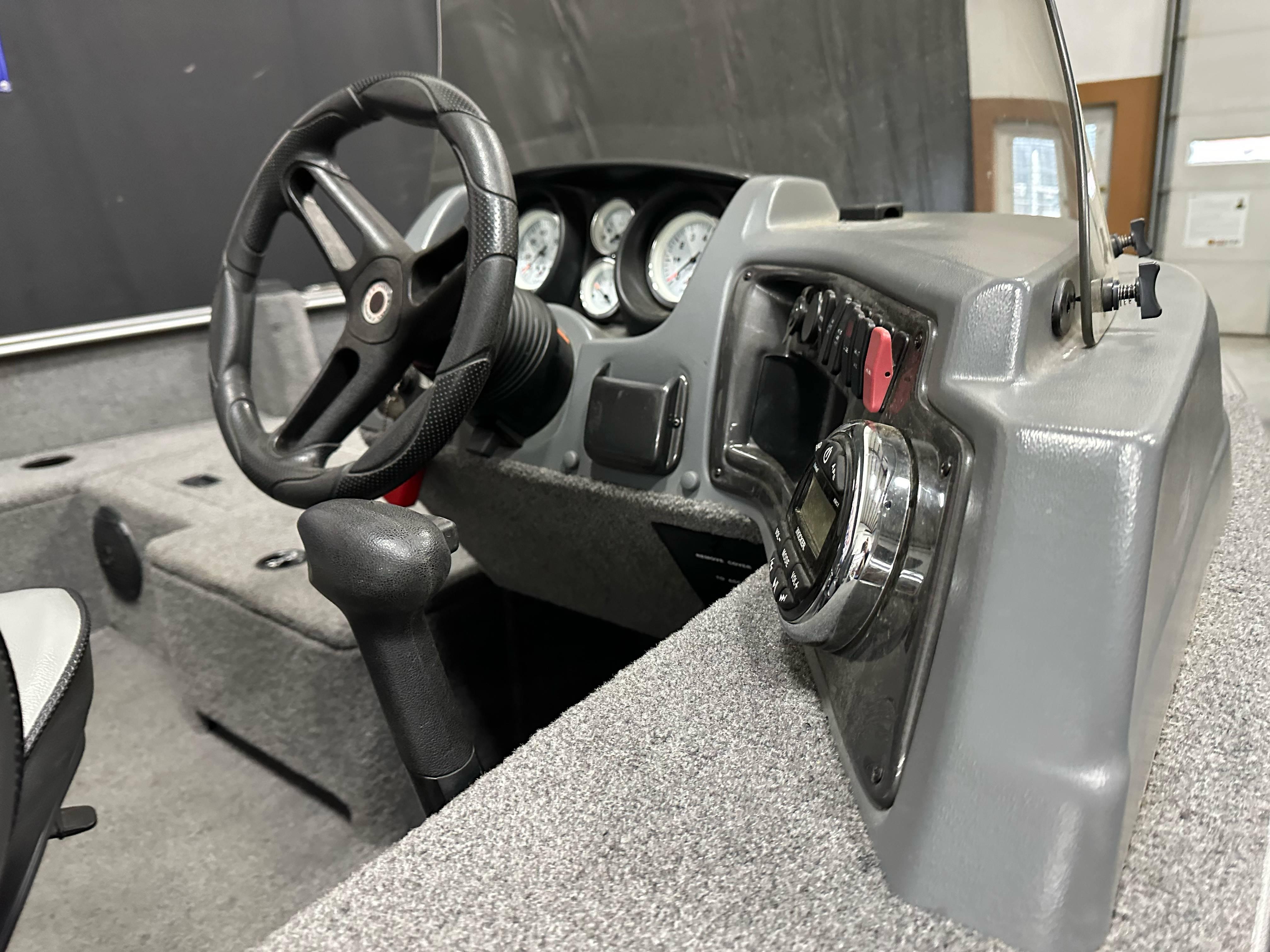 2017 Lund 1675 Impact SS boat dashboard with steering wheel and instrument panel.