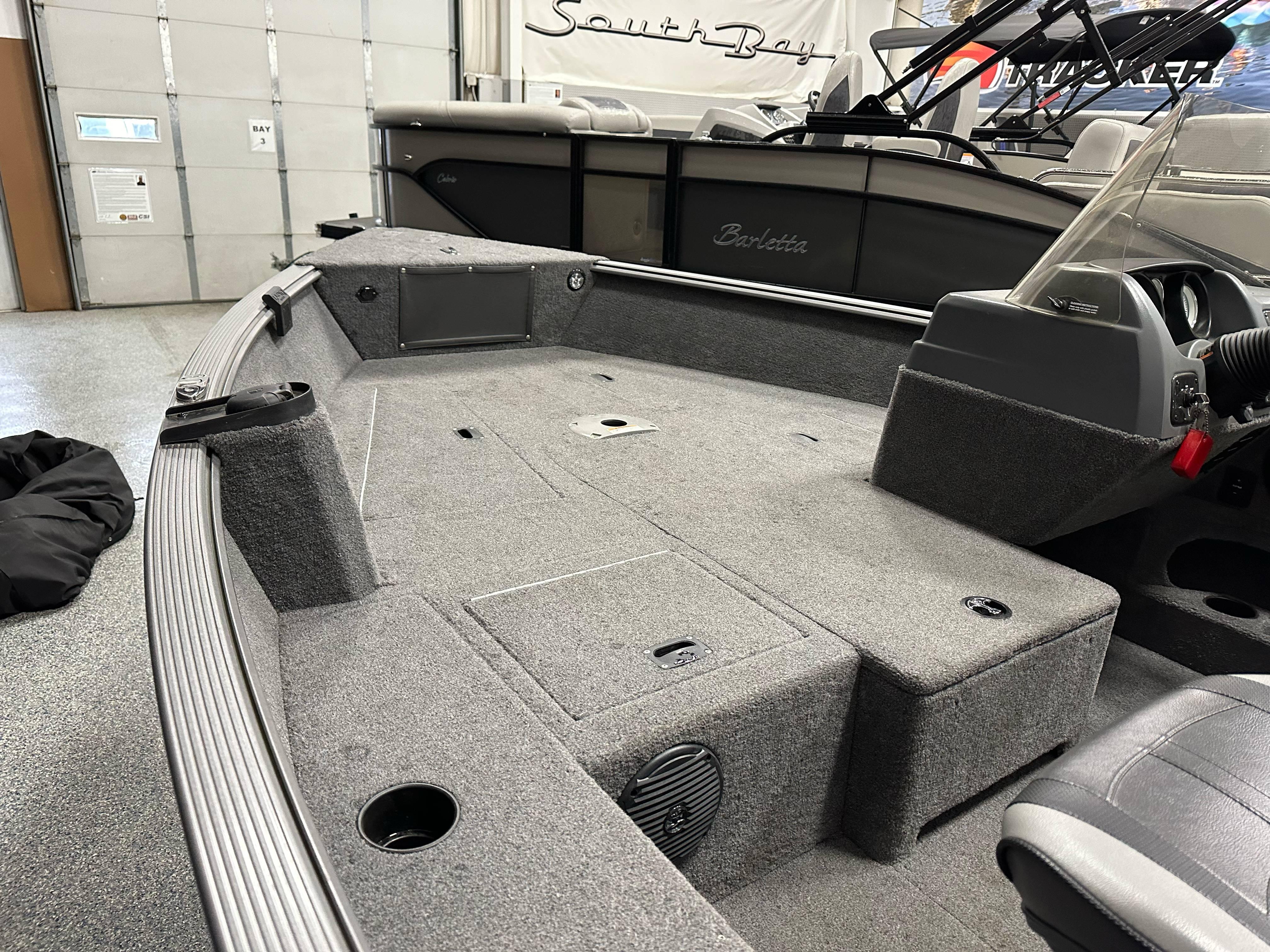 2017 Lund 1675 Impact SS boat interior with gray carpet and storage compartments.
