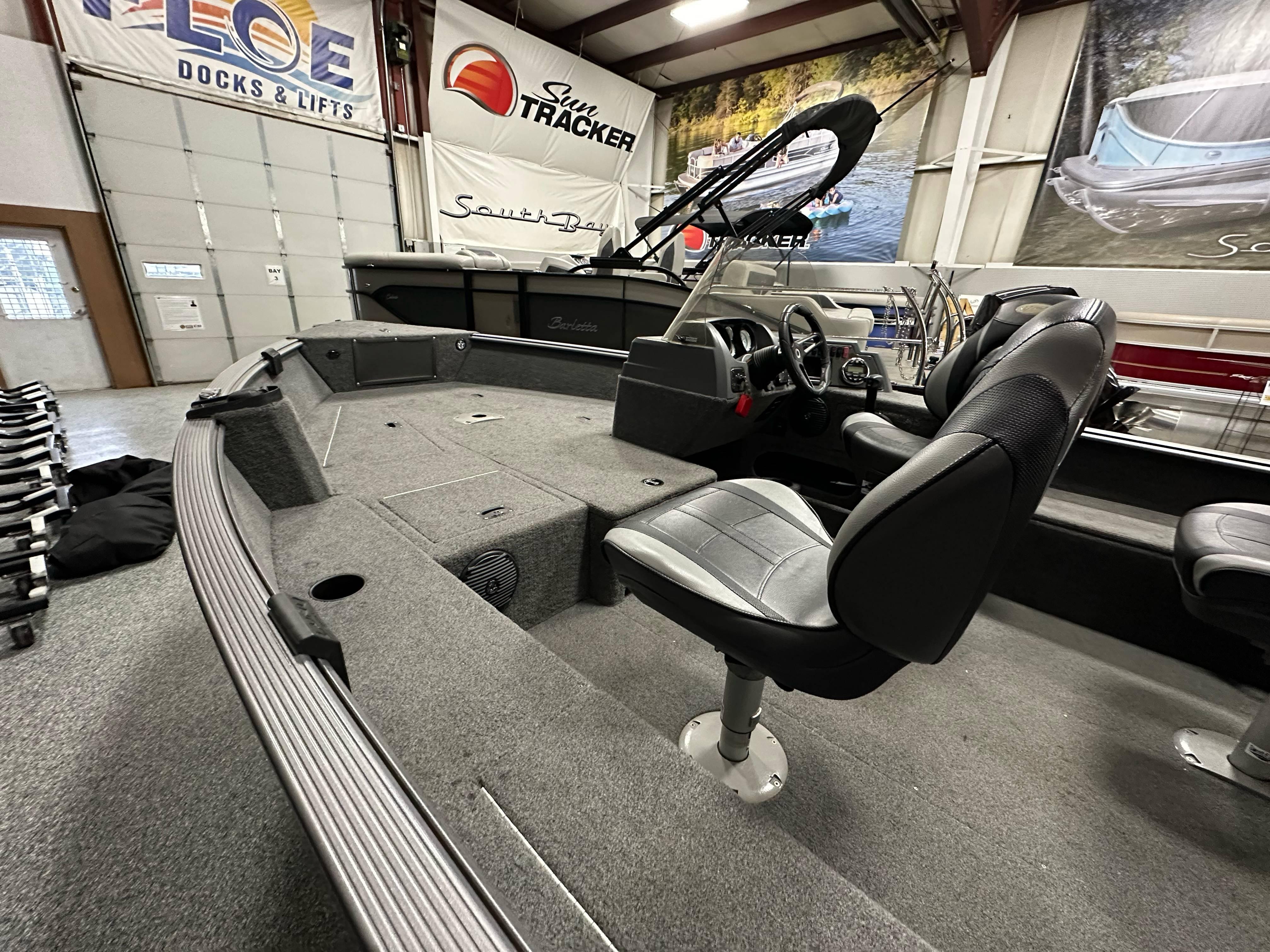 2017 Lund 1675 Impact SS boat interior with seating and steering console in showroom.