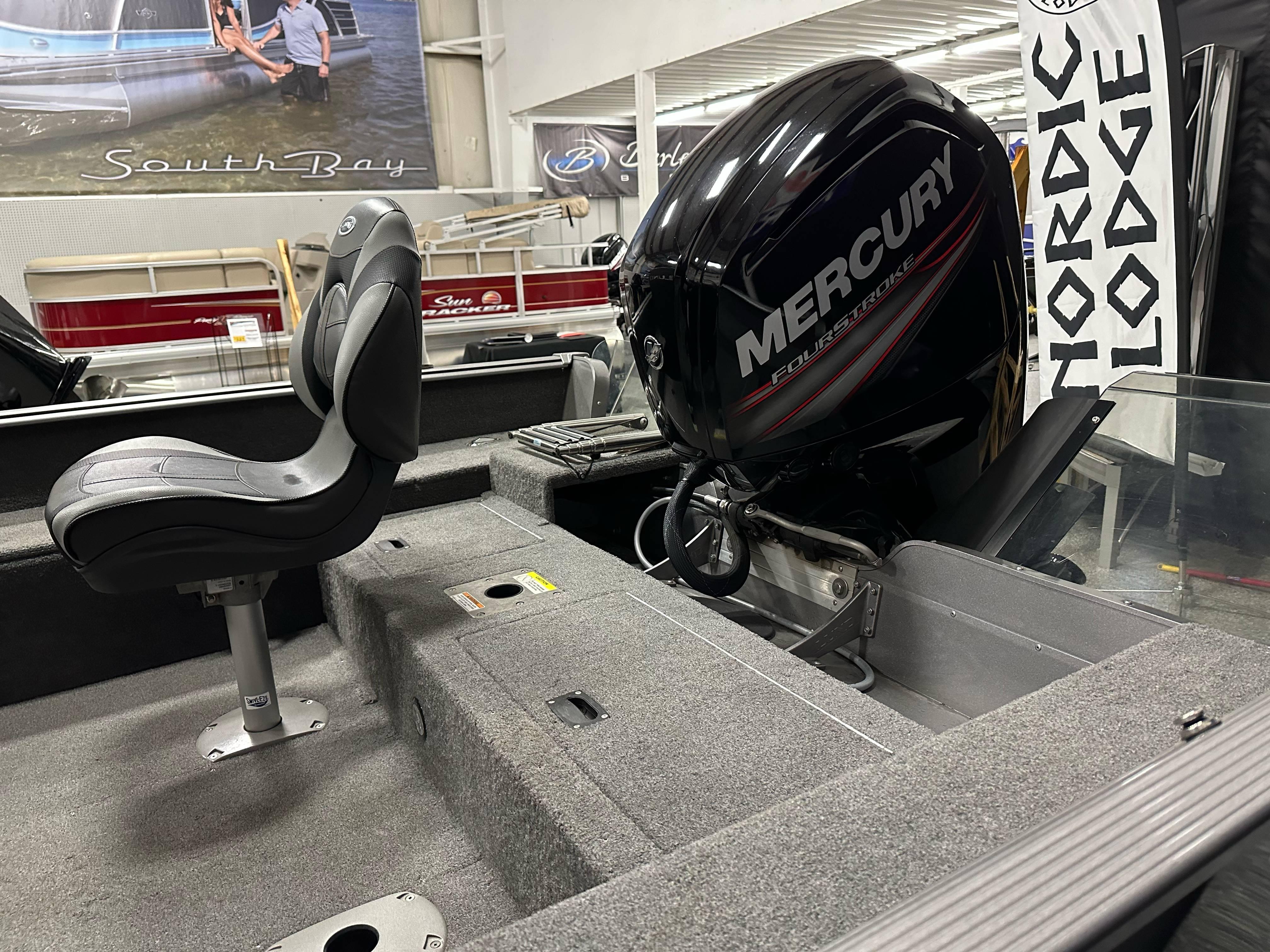 2017 Lund 1675 Impact SS boat interior with Mercury outboard motor in showroom.