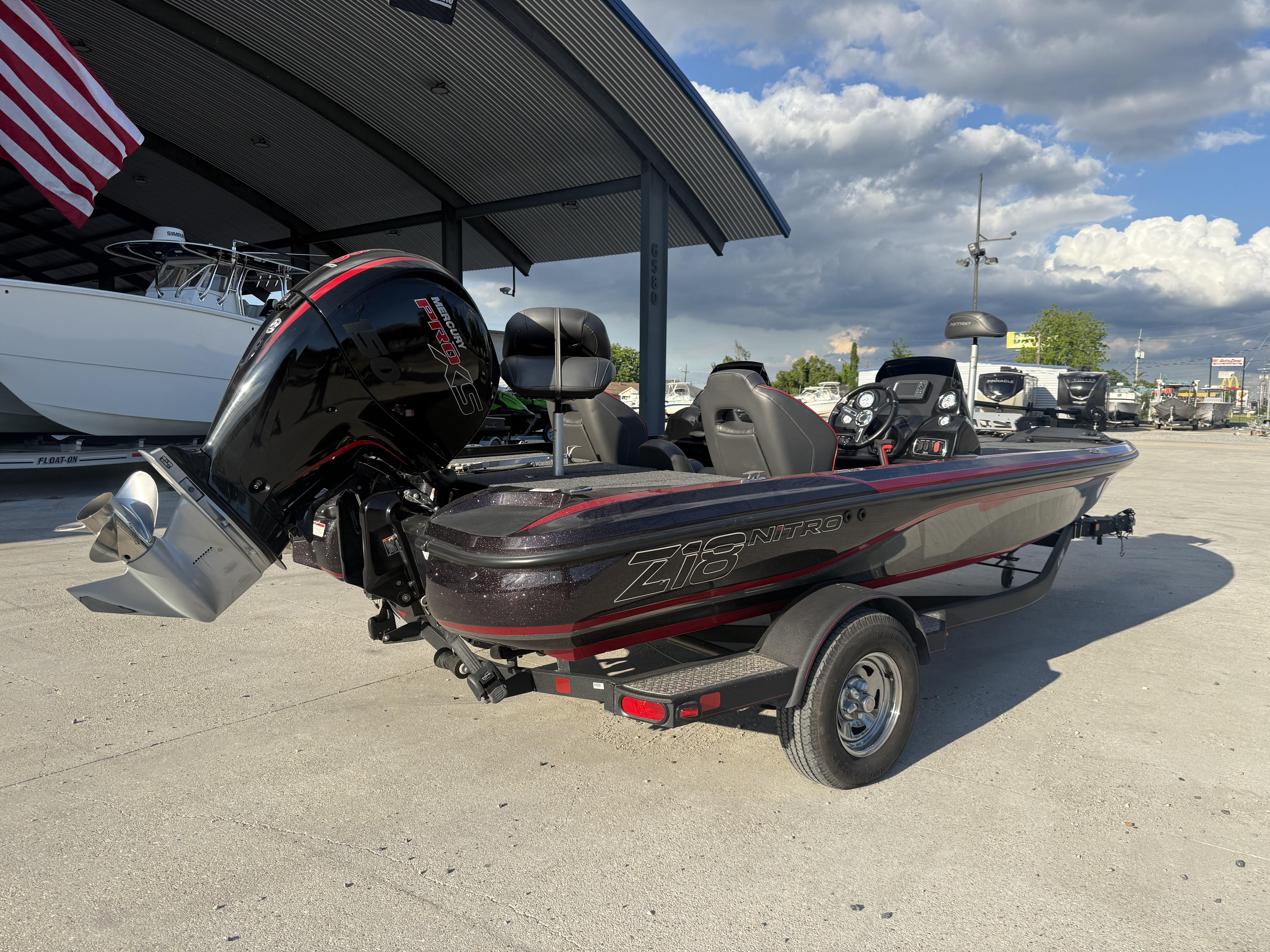 2019 Nitro Z18 DC boat with powerful outboard motor, parked outdoors under a cloudy sky.