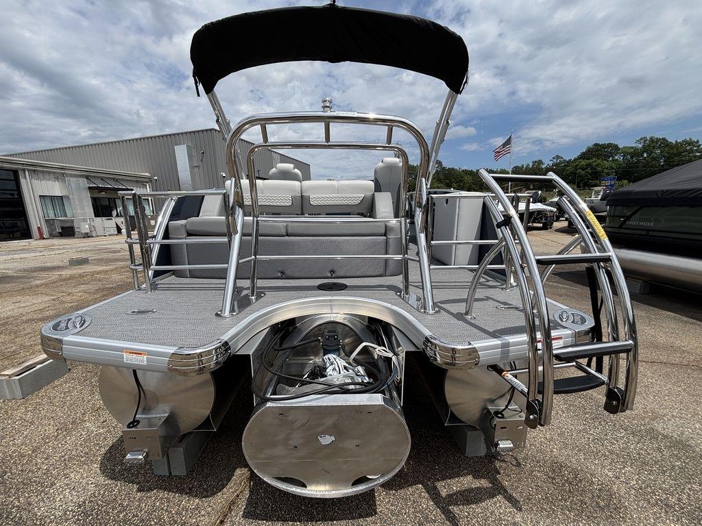 2025 Godfrey Monaco 235 DFL pontoon boat, rear view, docked under cloudy sky.