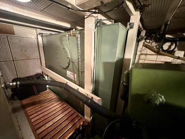 Engine room of 1982 Grand Banks Classic boat with machinery and pipes.