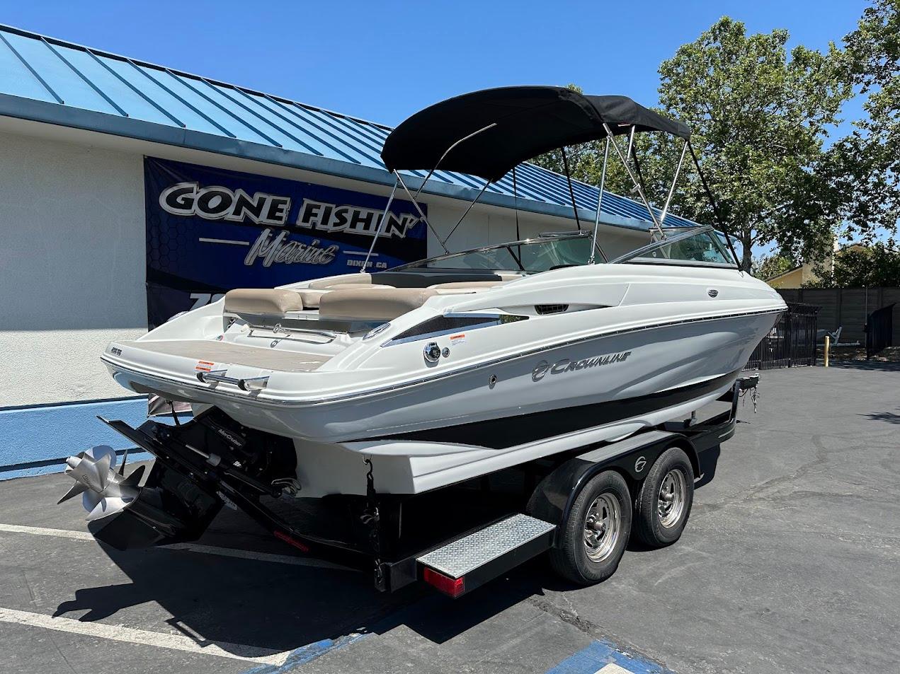 2019 Crownline 235 SS boat on trailer, parked outside dealership with blue roof.