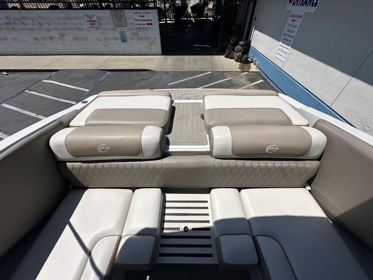 2019 Crownline 235 SS boat interior with beige and white seating in a parking area.