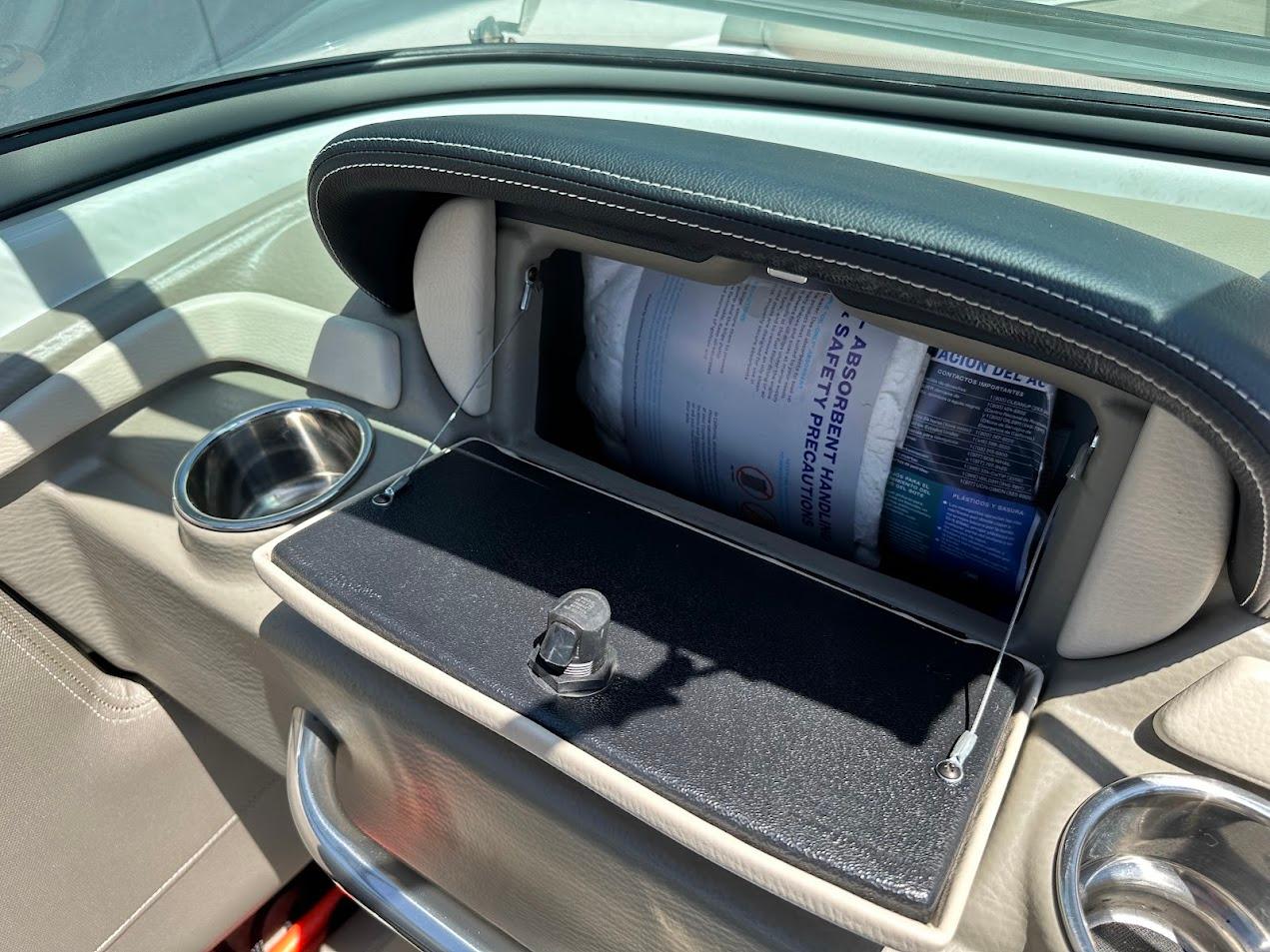 2019 Crownline 235 SS boat interior with open glove compartment and cup holders.