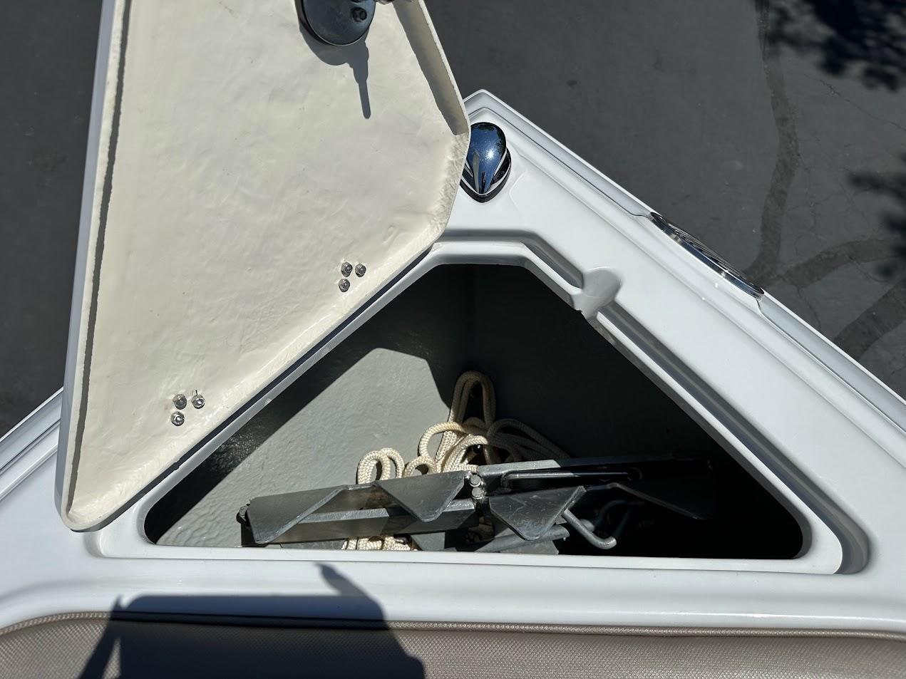 Open storage compartment on 2019 Crownline 235 SS boat with anchor and rope.