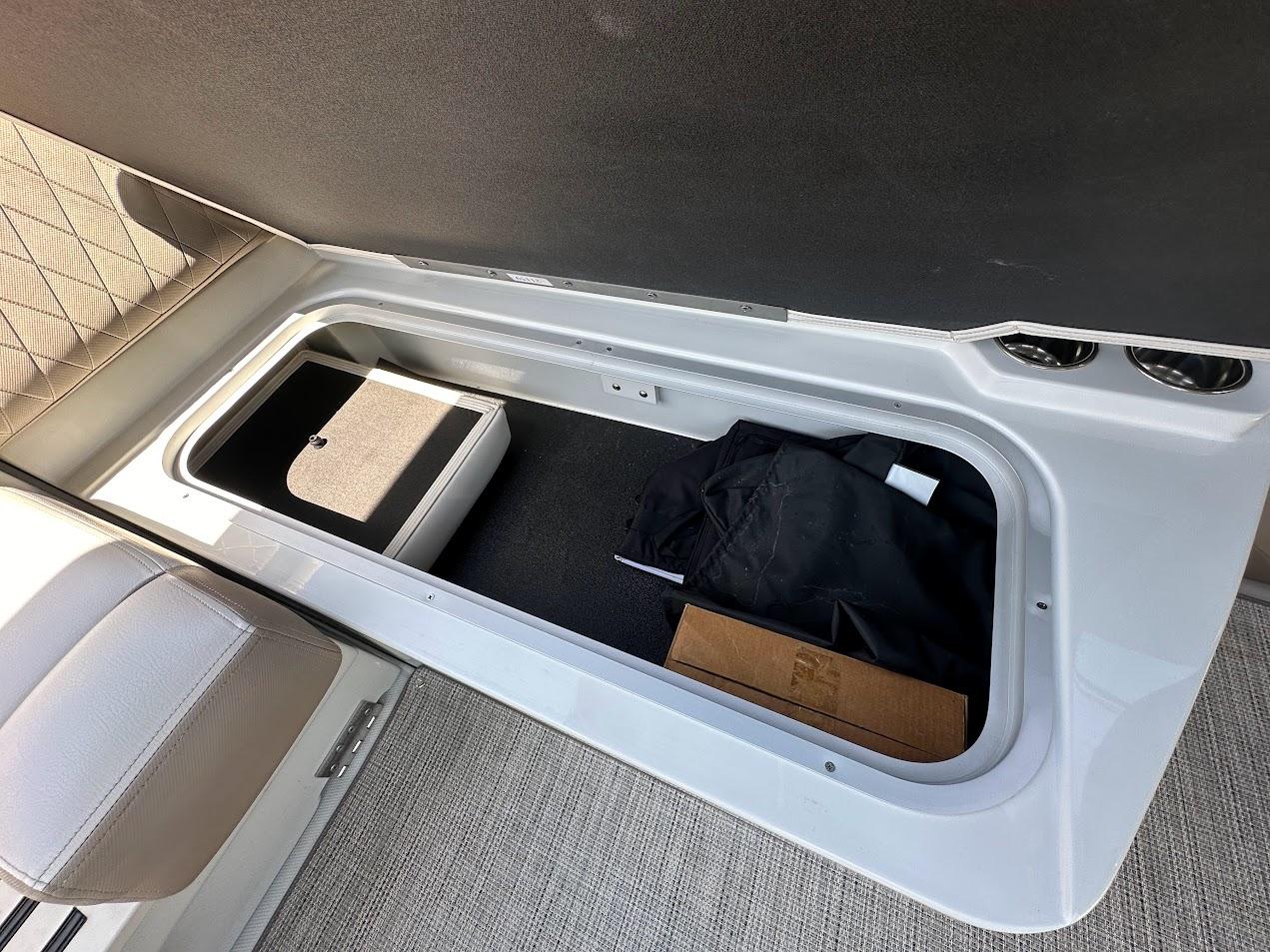 2019 Crownline 235 SS boat storage compartment with various items inside.
