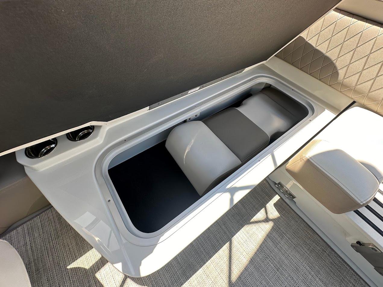 2019 Crownline 235 SS boat storage compartment with cushioned interior and carpeted flooring.