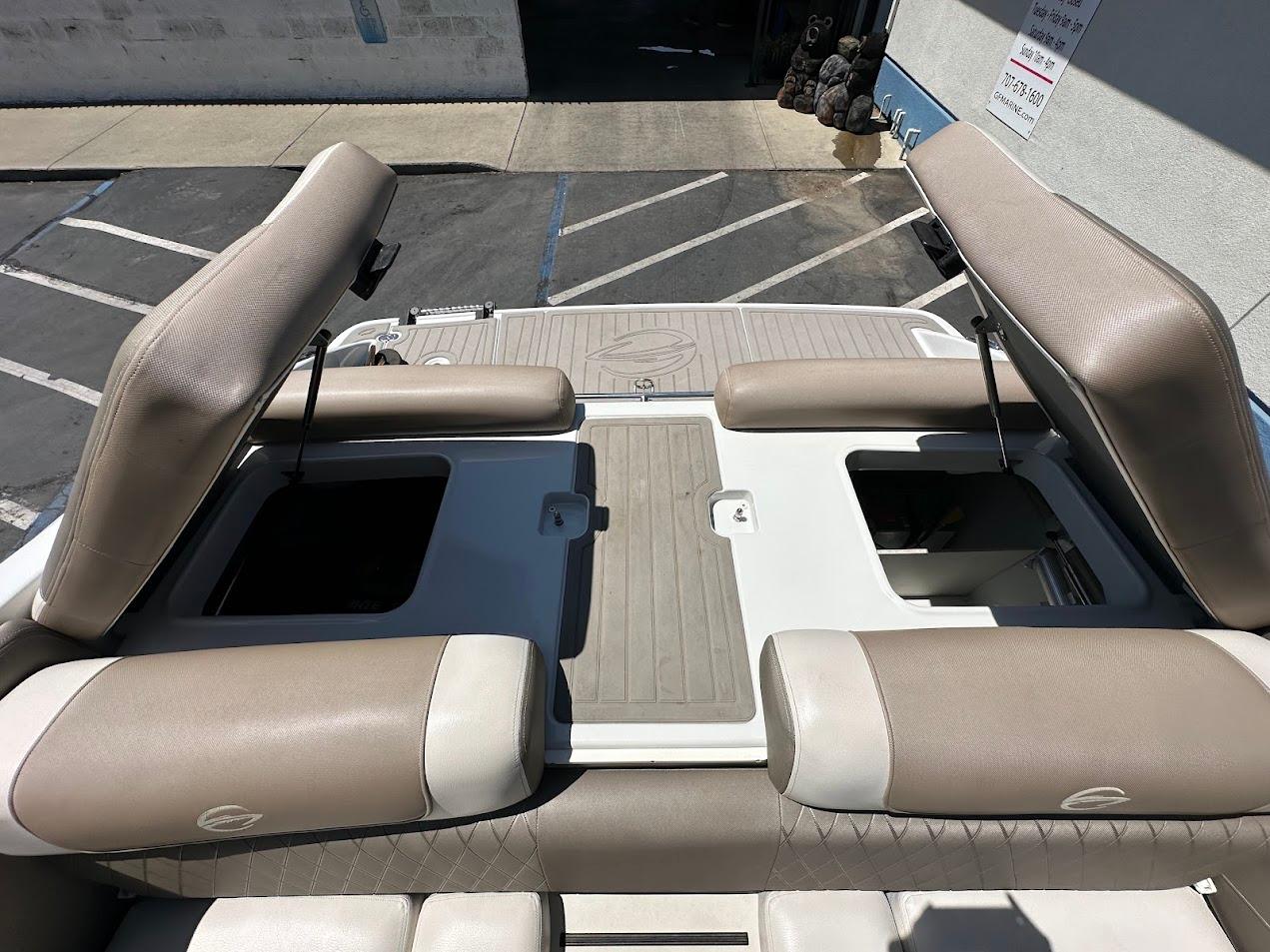 2019 Crownline 235 SS boat interior with open storage compartments and beige seating.