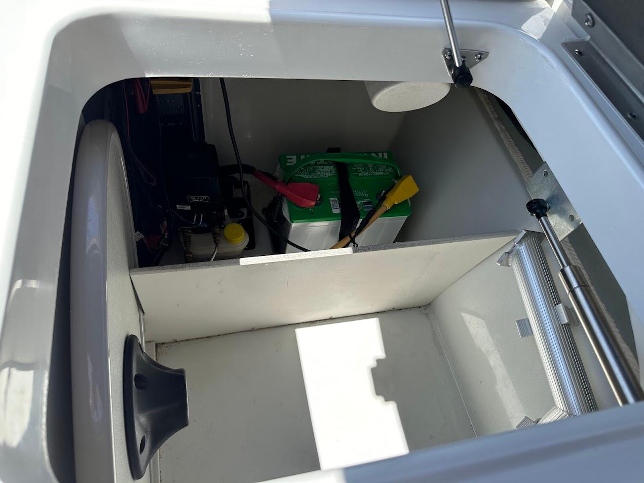 2019 Crownline 235 SS boat storage compartment with battery and tools.